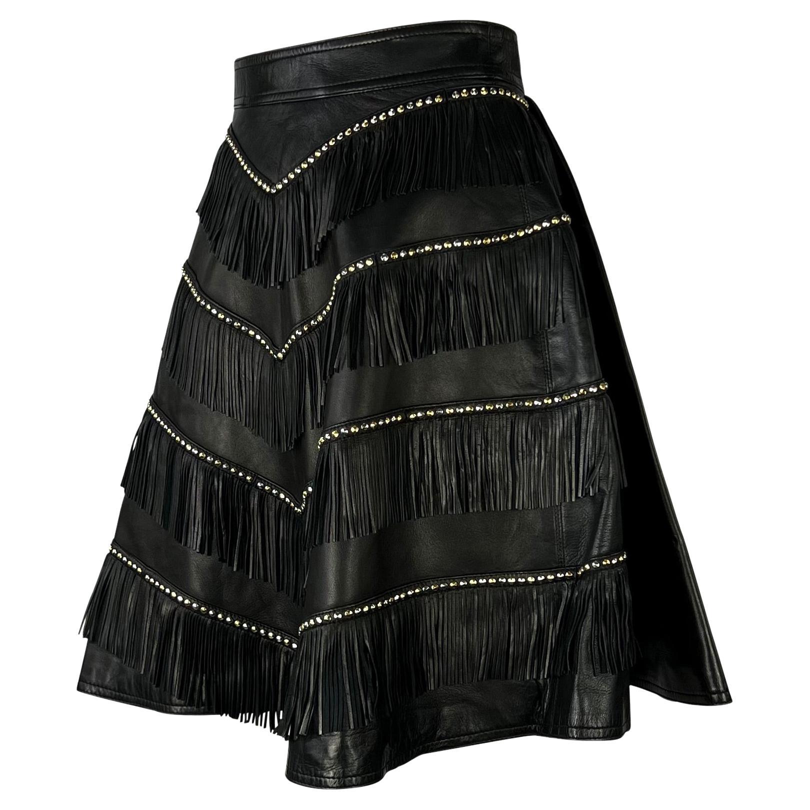 Presenting a studded leather A-line skirt designed by Gianni Versace for his infamous Fall/Winter 1992 'Miss S&M' bondage-inspired collection. Worn on the runway with the fringe and stud detailing on the back as part of look number 40, this piece is