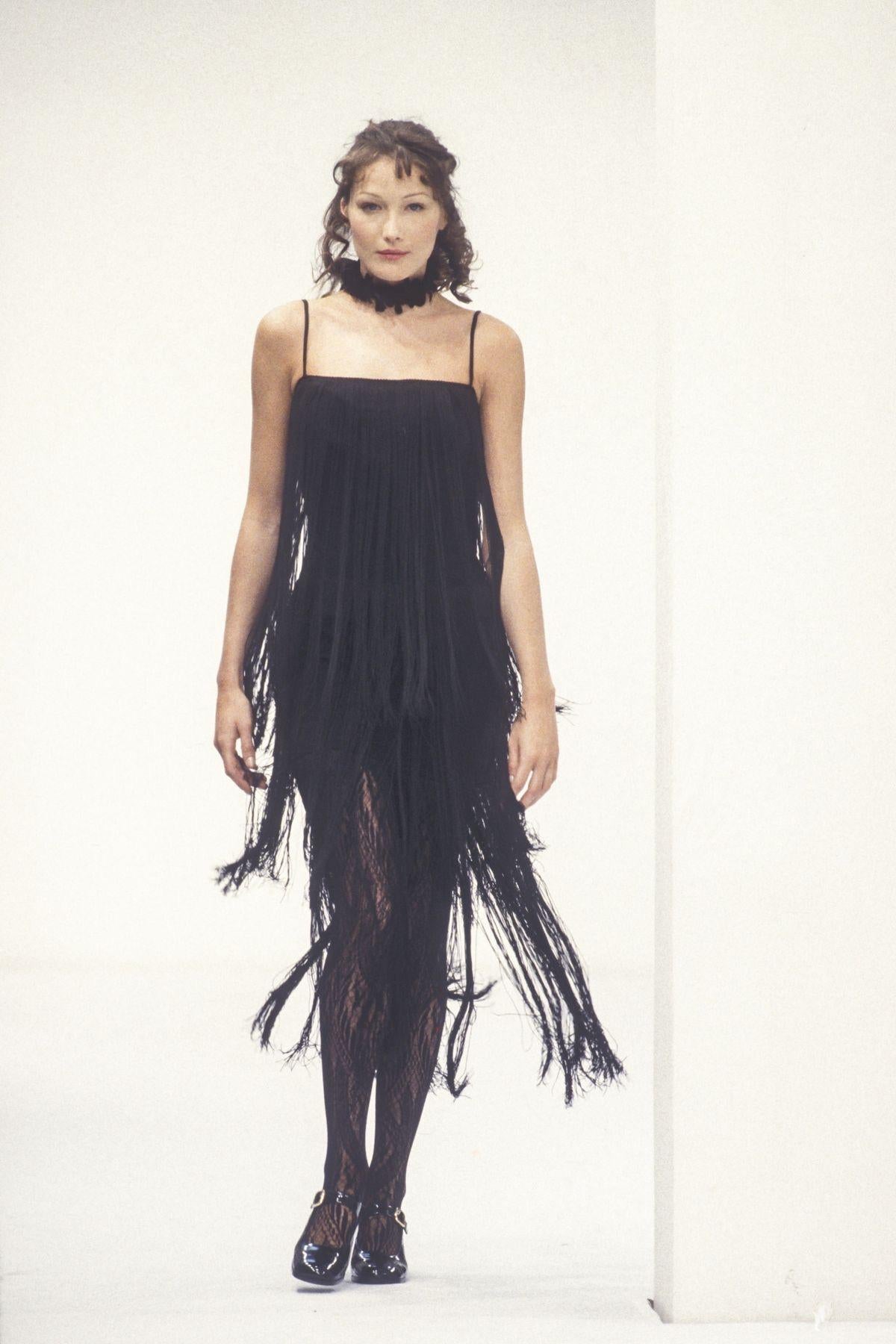 Presenting a chic navy fringe flapper-style Dolce & Gabbana dress. From the Fall/Winter 1993 collection, this mini dress debuted on the season's runway on Carla Bruni, with a similar dress highlighted in the season's ad campaign, captured by Steven