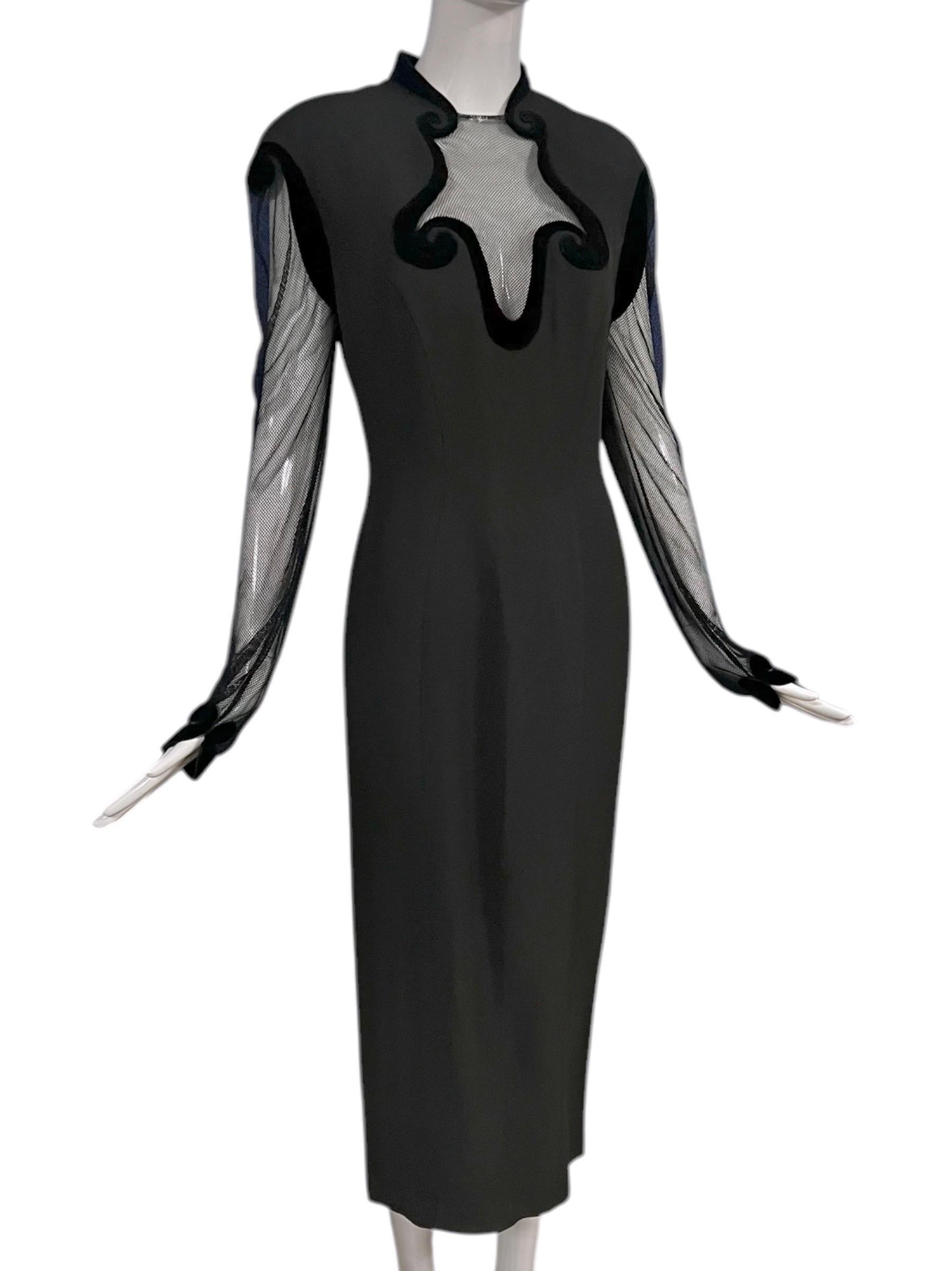 This Thierry Mugler Fall Winter 1993 dress is a striking vintage piece that embodies the designer’s signature avant-garde aesthetic. It features a form-fitting black silhouette with a striking cutout neckline framed by black velvet, creating a