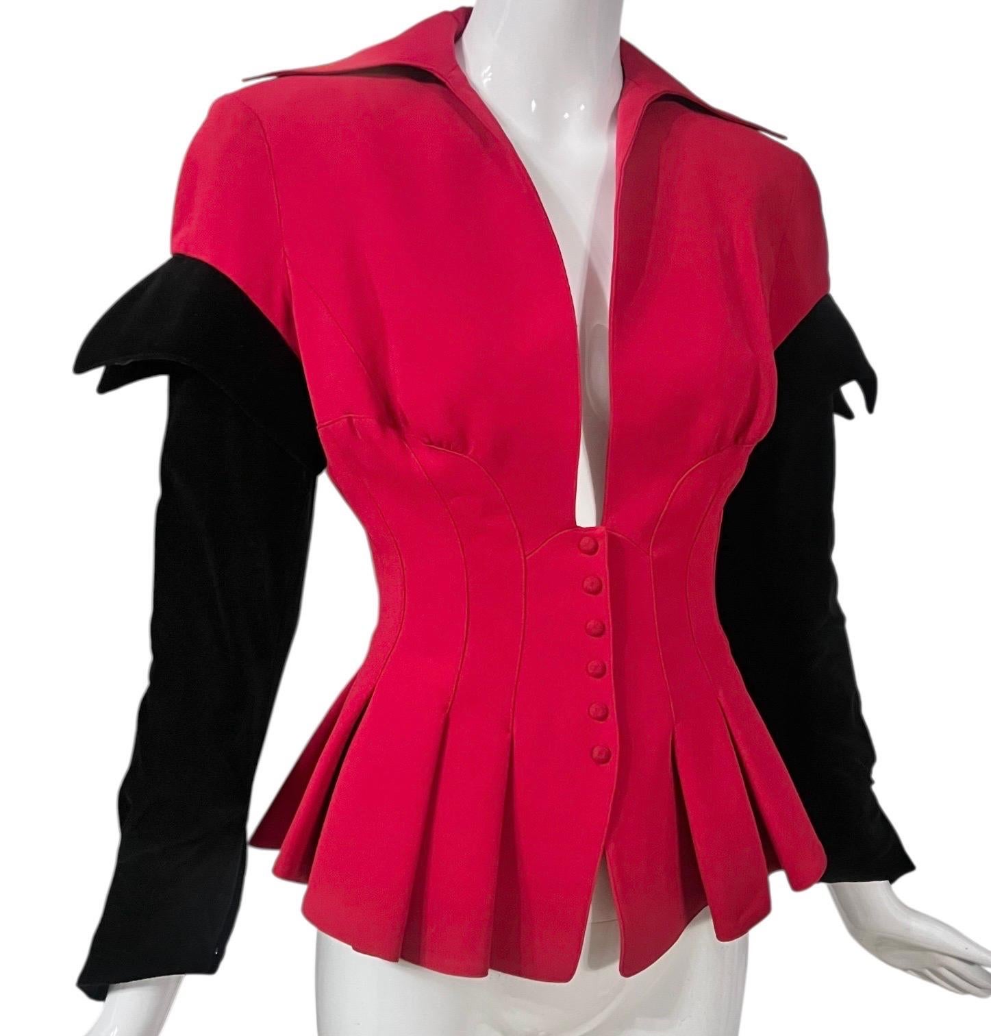 Diese Vintage-Jacke aus der Herbst-Winter-Kollektion 1993 von Thierry Mugler ist ein kühnes Beispiel für seine charakteristische skulpturale Schnittführung und futuristische Weiblichkeit.  Diese Jacke in feurigem Feuerrot zeichnet sich durch eine