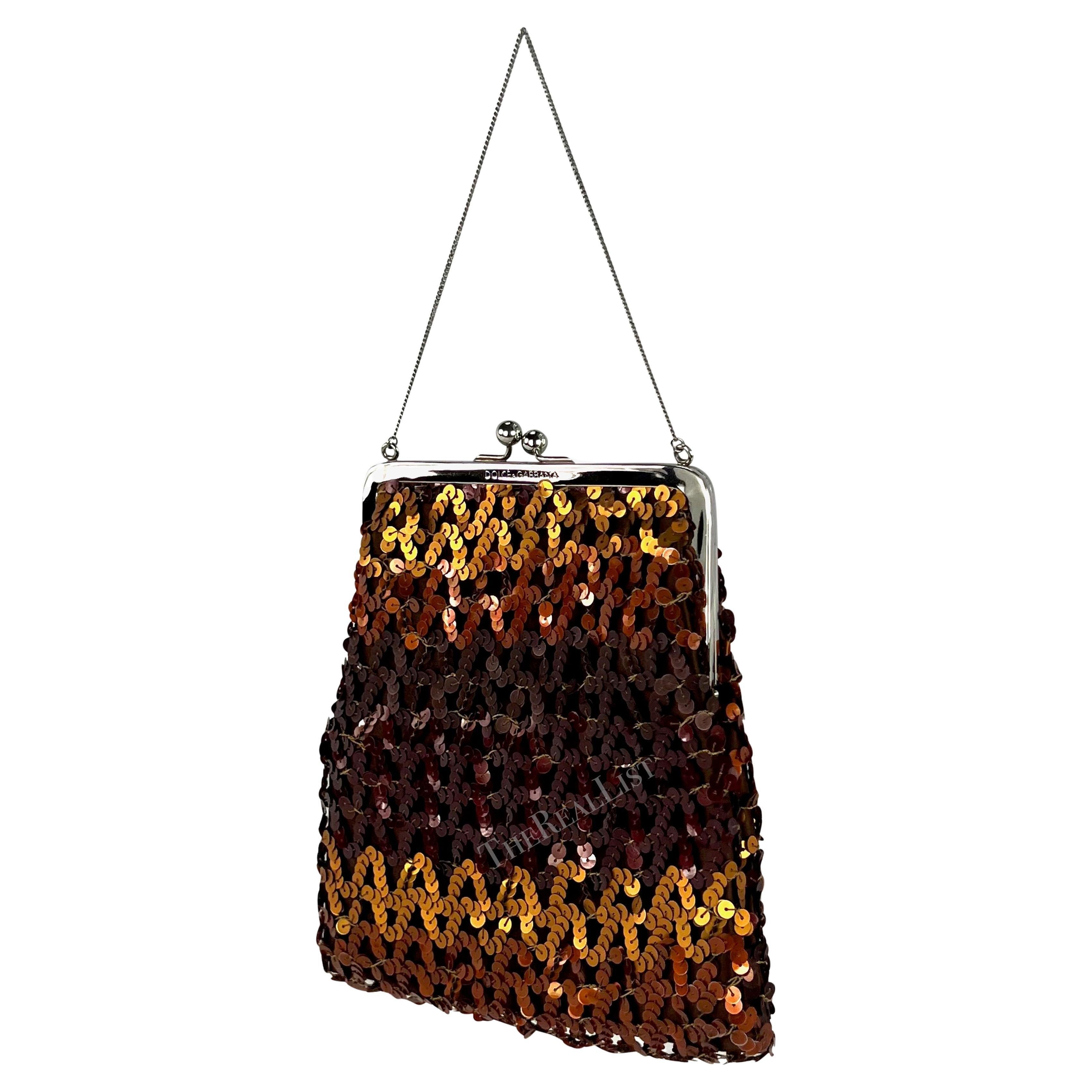 Voici un superbe sac Dolce & Gabbana à paillettes couleur miel de la collection automne-hiver 1994. Cet élégant sac à clapet est doté d'une délicate anse en chaîne de couleur argentée et d'accessoires de couleur argentée. Il est composé d'une base