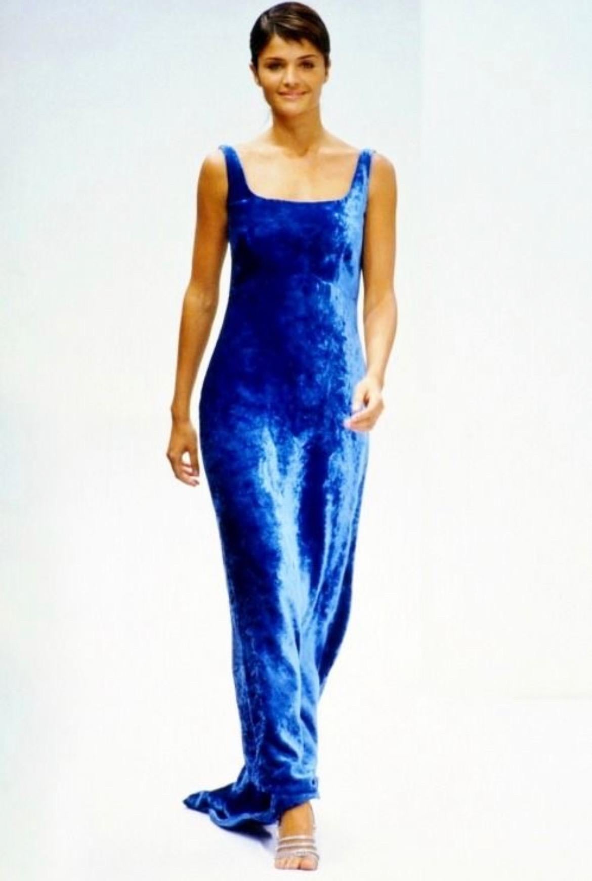Elle présente une magnifique robe Dolce and Gabbana en velours marron. Issue de la collection Automne/Hiver 1994, la version bleue de cette fabuleuse robe a fait ses débuts sur le podium de la saison, portée par Helena Christensen. Cette robe chic