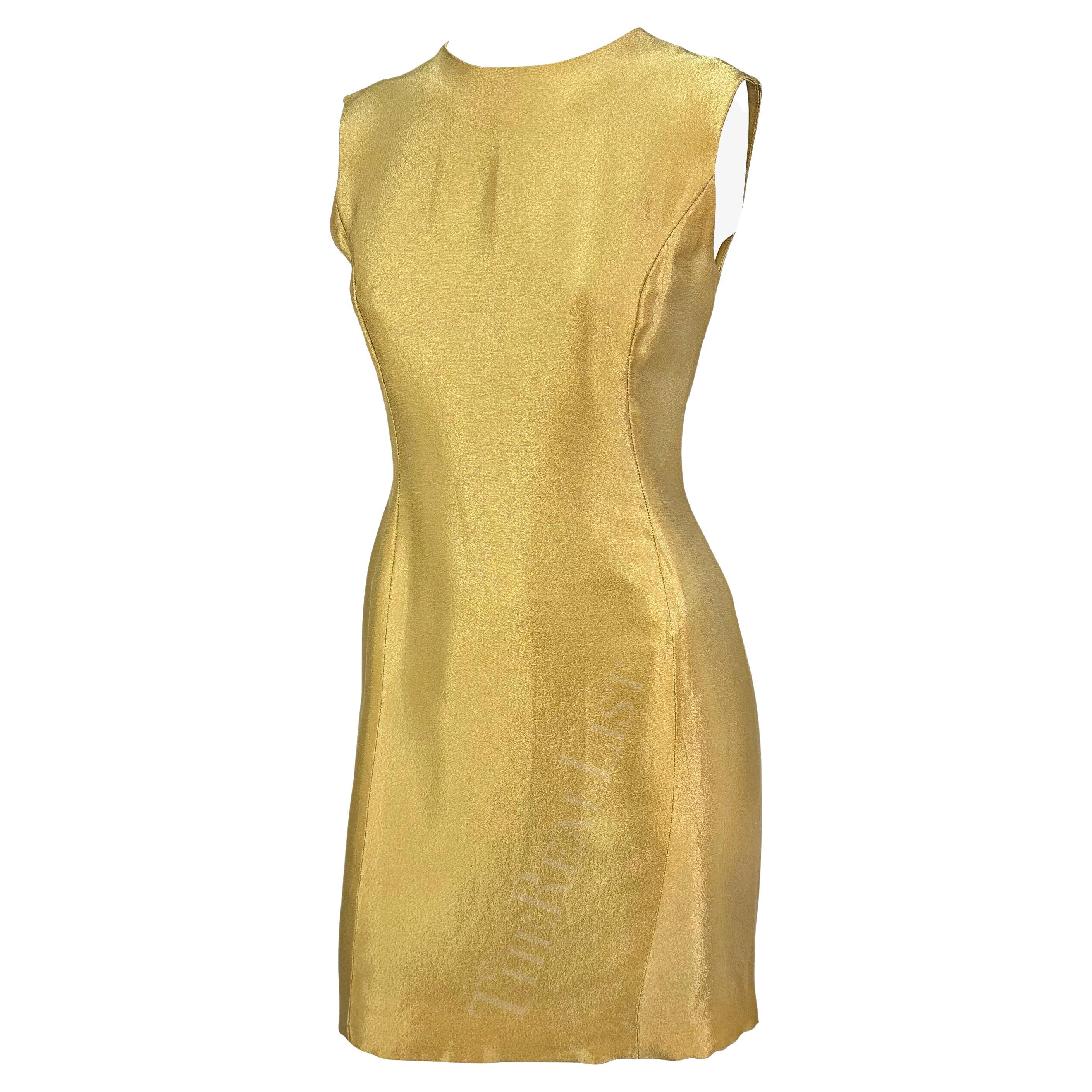 Nous vous présentons une fabuleuse robe Gianni Versace en or métallisé, créée par Gianni Versace. Issue de la collection Automne/Hiver 1994, cette robe est entièrement réalisée en soie mélangée or métallisé chatoyant. Cette robe sans manches