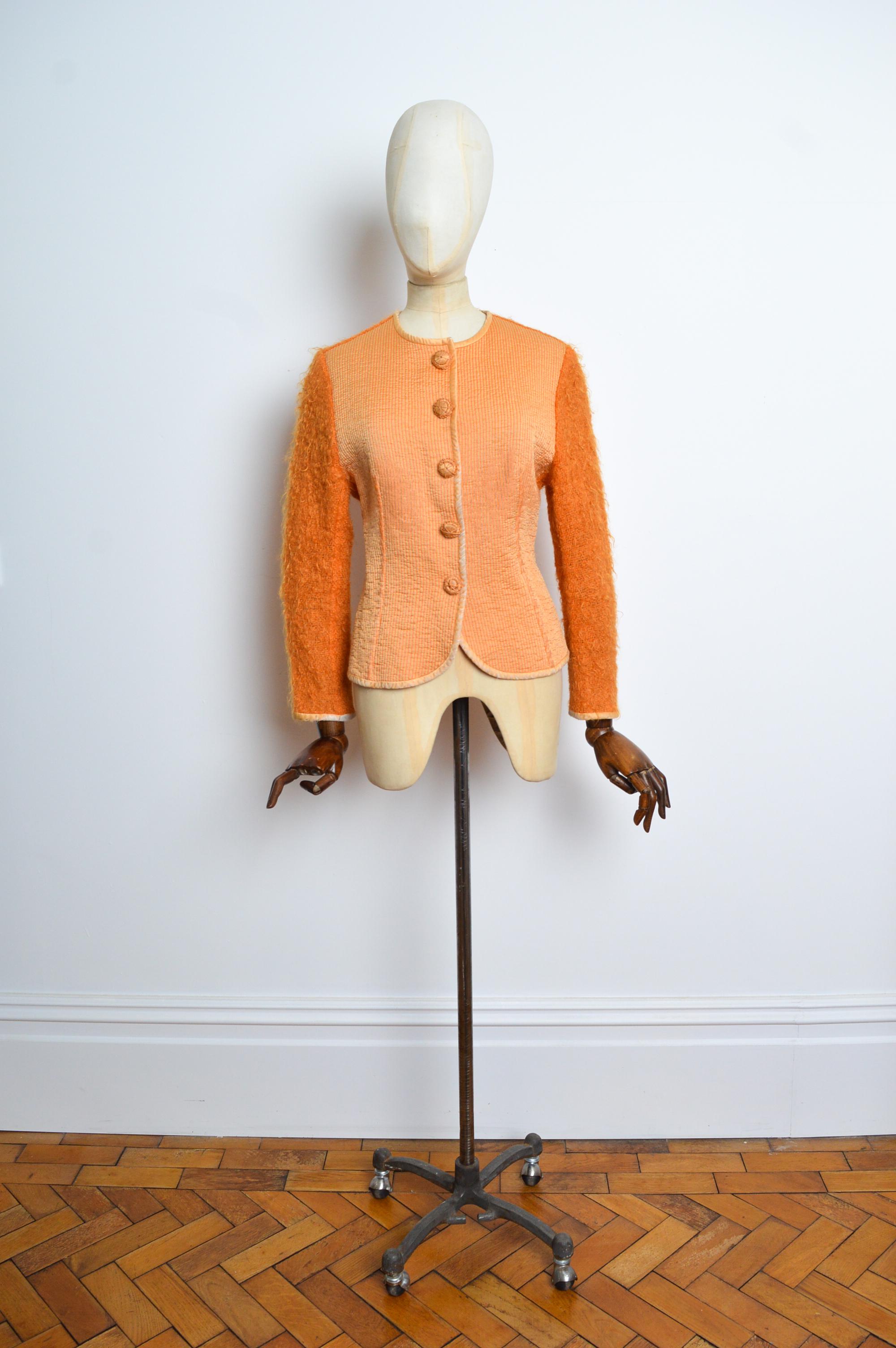Superb Mohair & Raw silk collar-less jacket in a tangerine colour with decorative press stud closure buttons down the front. Designed by Gianfranco Ferré for Christian Dior’s Fall 1995 Collection.
Size; label states 46 / We would recommend to best
