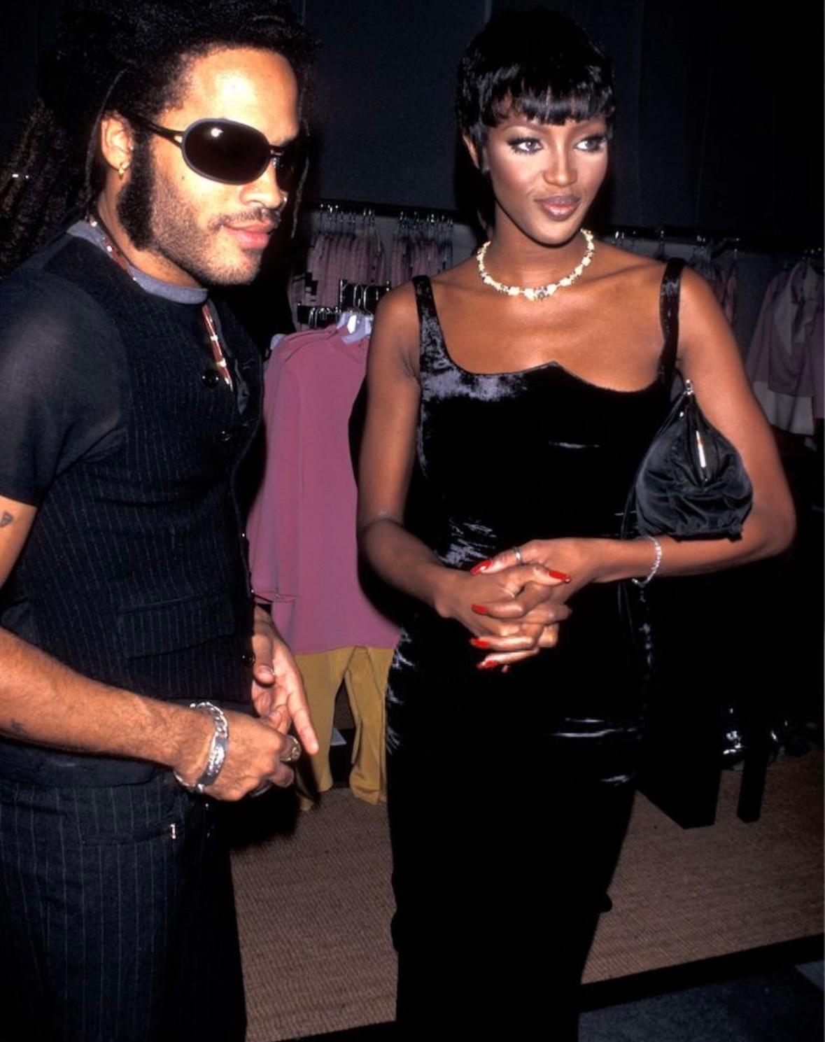 This Fall/Winter 1995 Gianni Versace evening gown is crafted from luxurious crushed black velvet, featuring a structured sweetheart neckline and a figure-hugging silhouette. Worn as look 59 on the runway by Eva Herzigova, the gown was also famously