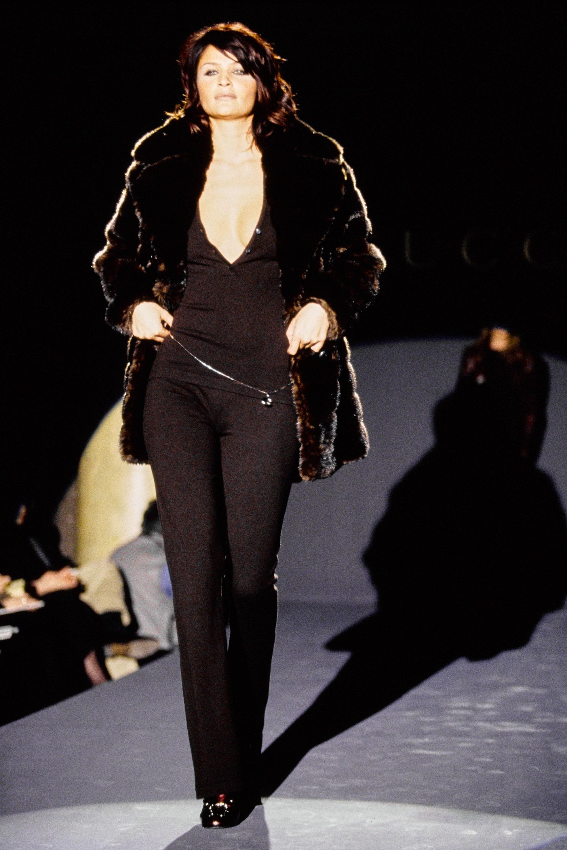 Voici un fabuleux duffle-coat en fausse fourrure marron de Gucci, dessiné par Tom Ford. Issu de la collection Automne/Hiver 1995, ce manteau surdimensionné a fait ses débuts sur le podium de la saison dans le cadre du look 39 porté par Helena
