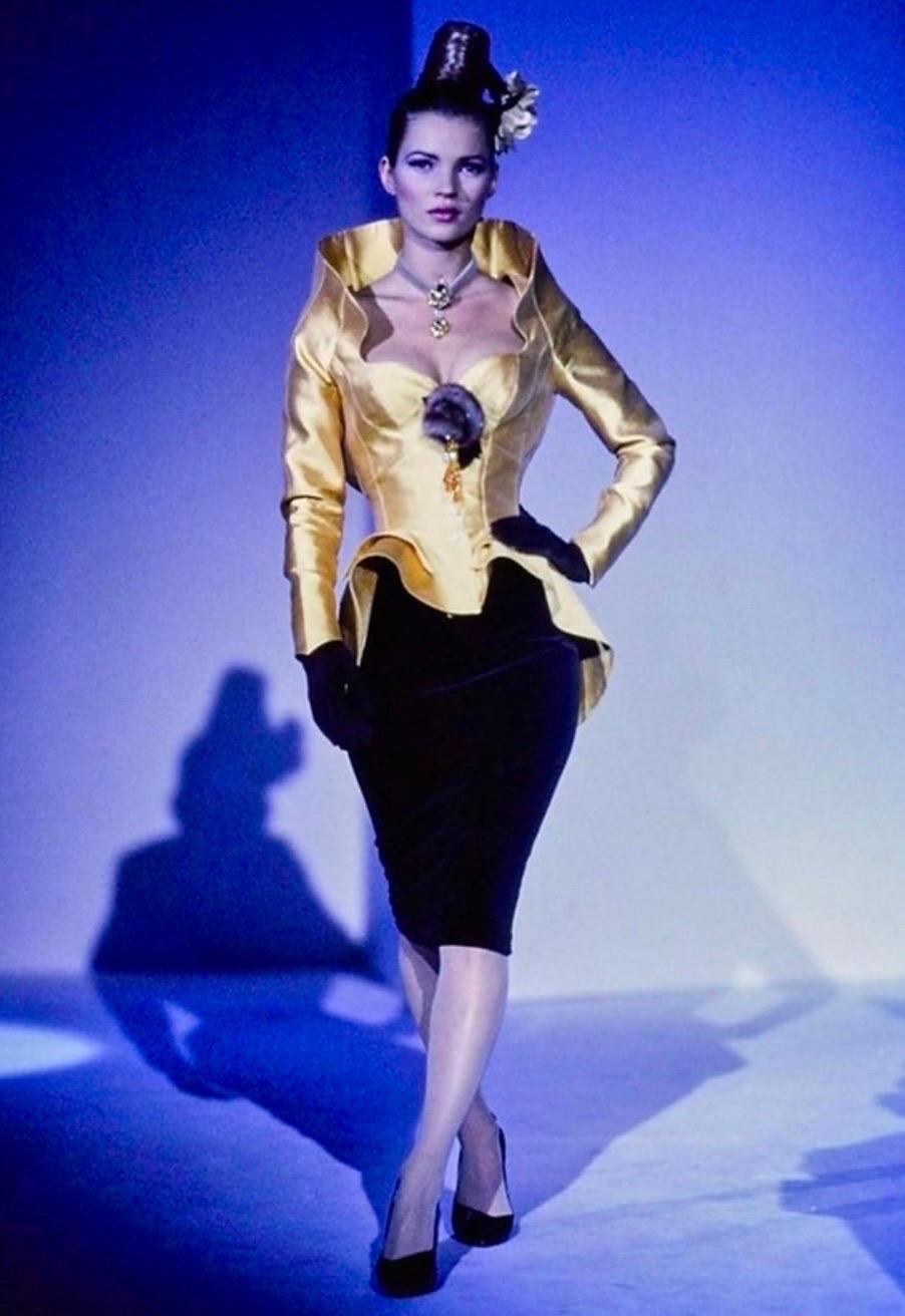 Ultra rare highly collectible magnificent sculptural gold jacket from the iconic Fall Winter 1995 collection
The same jacket was worn on the Cirque d’Hiver runway by Kate Moss
Features a high stand collar, peplum flared waist, faux pearl snap