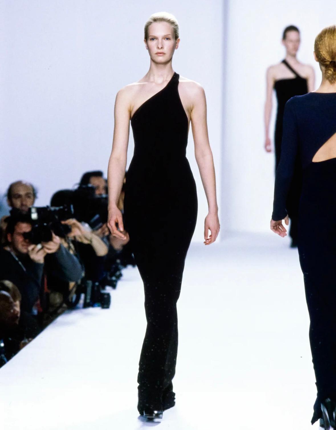 With a variation debuting as Look 68 on the Fall/Winter 1996 Calvin Klein runway, modeled by Christina Kruse, this form-fitting black gown is a classic knockout. This stretch gown is the elevated essential that every wardrobe needs. This beautiful