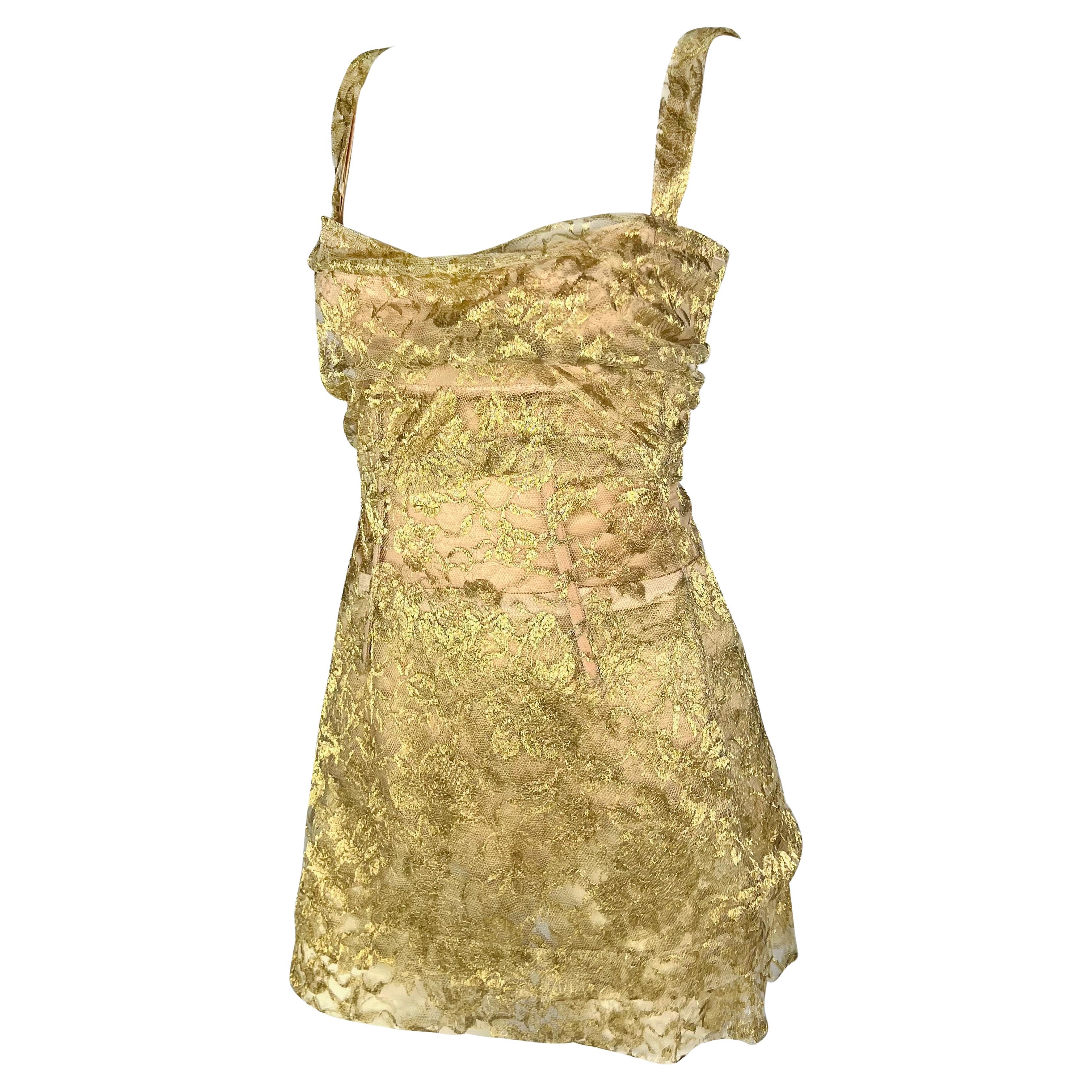 From the Fall/Winter 1996 collection, fabric-wrapped bodysuits akin to this gold lace-covered Dolce & Gabbana dress made their debut on the season's runway. This dress stands out as the ultimate party attire. Its ultra-mini length, thin straps, and