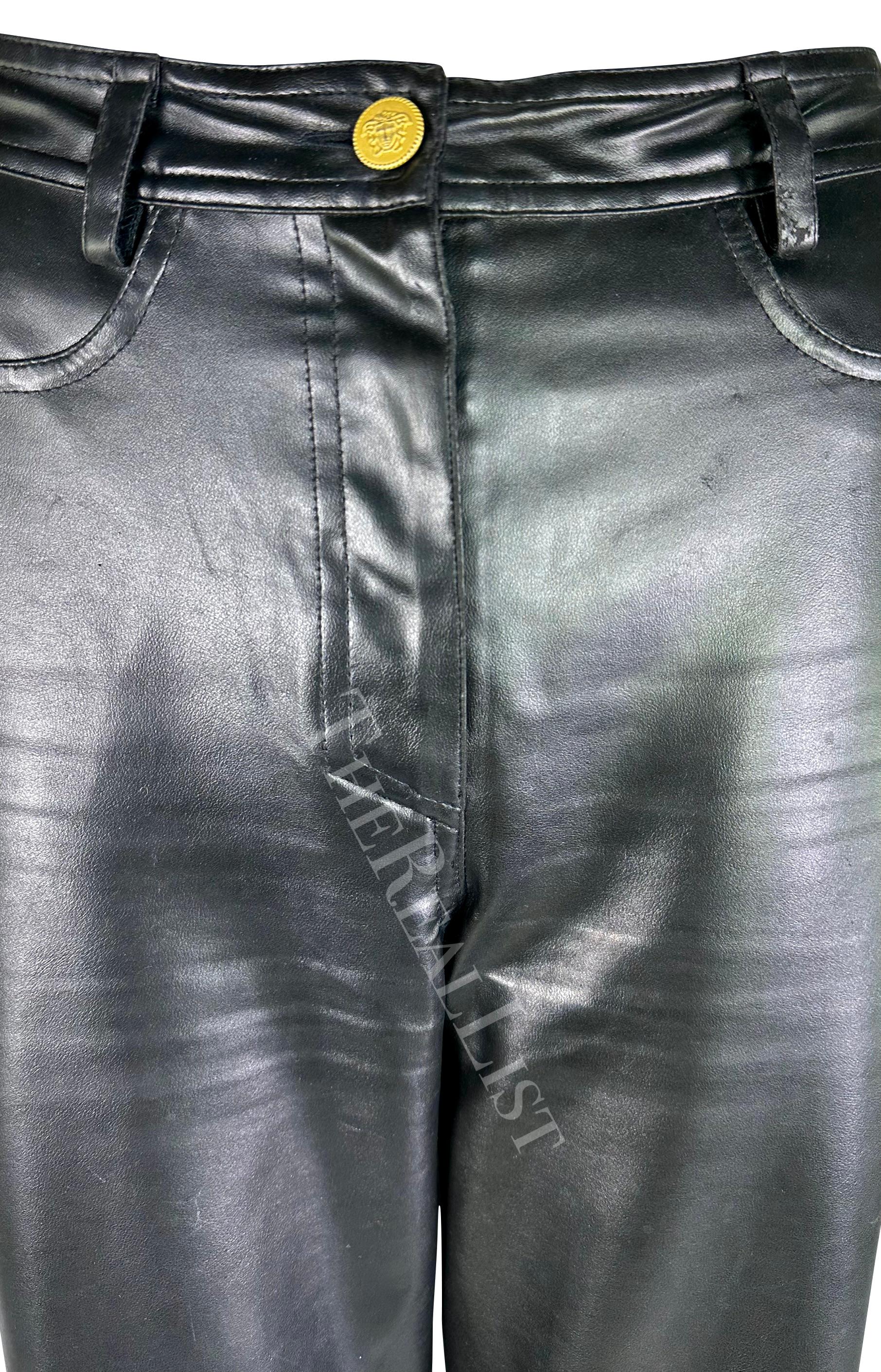 Presenting a pair of black faux leather Gianni Versace pants, designed by Gianni Versace. From the Fall/Winter 1996 collection, these pants are crafted from shiny vegan leather. Featuring a straight cut and a striking gold-tone Versace Medusa relief