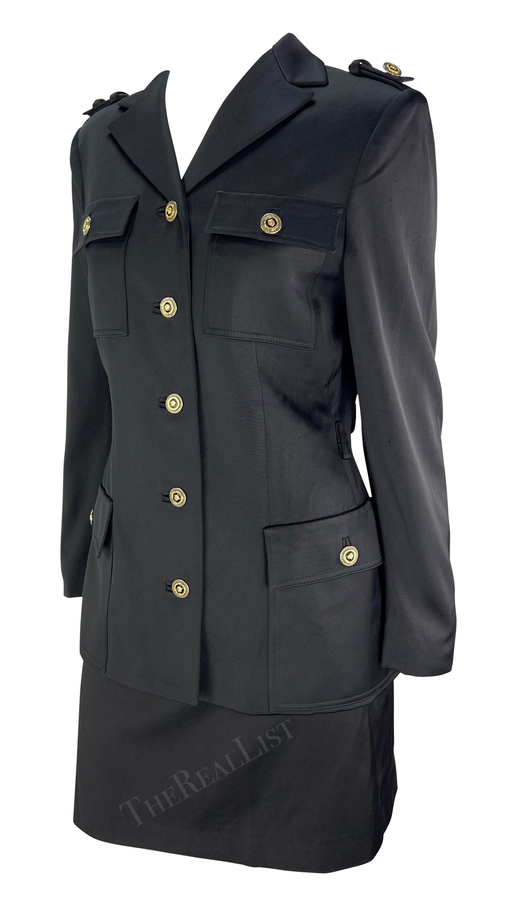 Ti presentiamo un elegante tailleur nero con gonna di Gianni Versace, disegnato da Gianni Versace. Dalla collezione Autunno/Inverno 1996, questo tailleur con gonna è composto da un blazer nero satinato e da una gonna a tubino abbinata. La giacca di