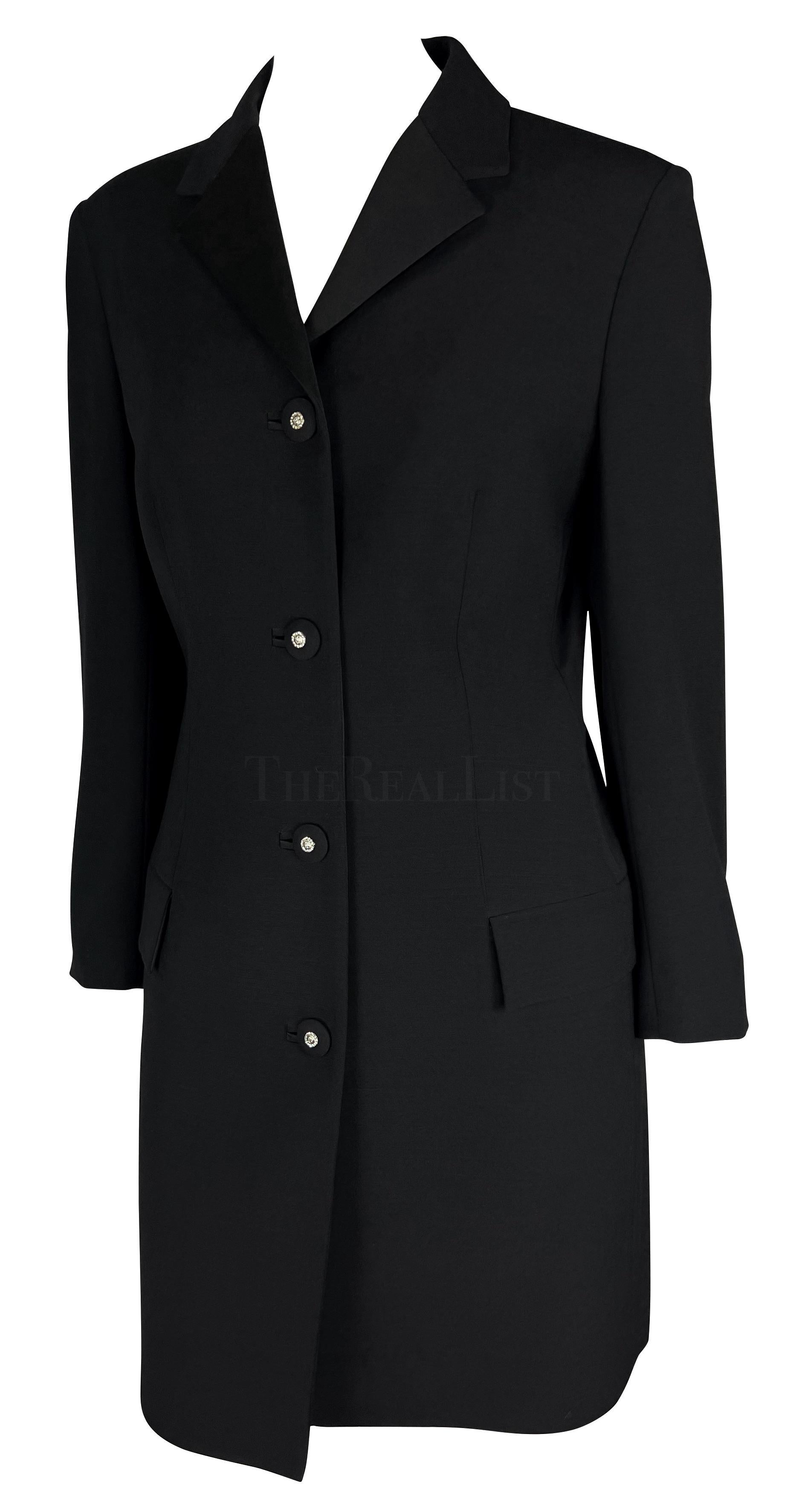 Dieser wunderschöne schwarze Wollmantel wurde von Gianni Versace für seine Herbst/Winter-Kollektion 1996 entworfen, wobei mehrere ähnliche lange Mäntel auf dem Laufsteg der Saison zu sehen waren. Die Jacke hat ein kurzes Revers und strassbesetzte