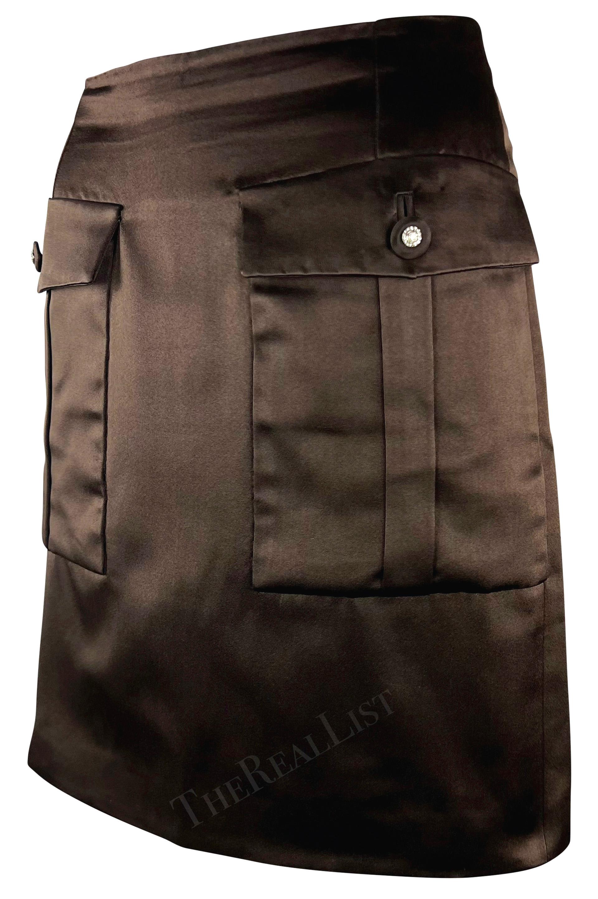 Introducing a fabulous brown satin Gianni Versace short skirt, designed by  Gianni Versace for the Fall/Winter 1996 collection. This chic silk skirt, crafted entirely from brown satin, showcases two large flap pockets at the front embellished with