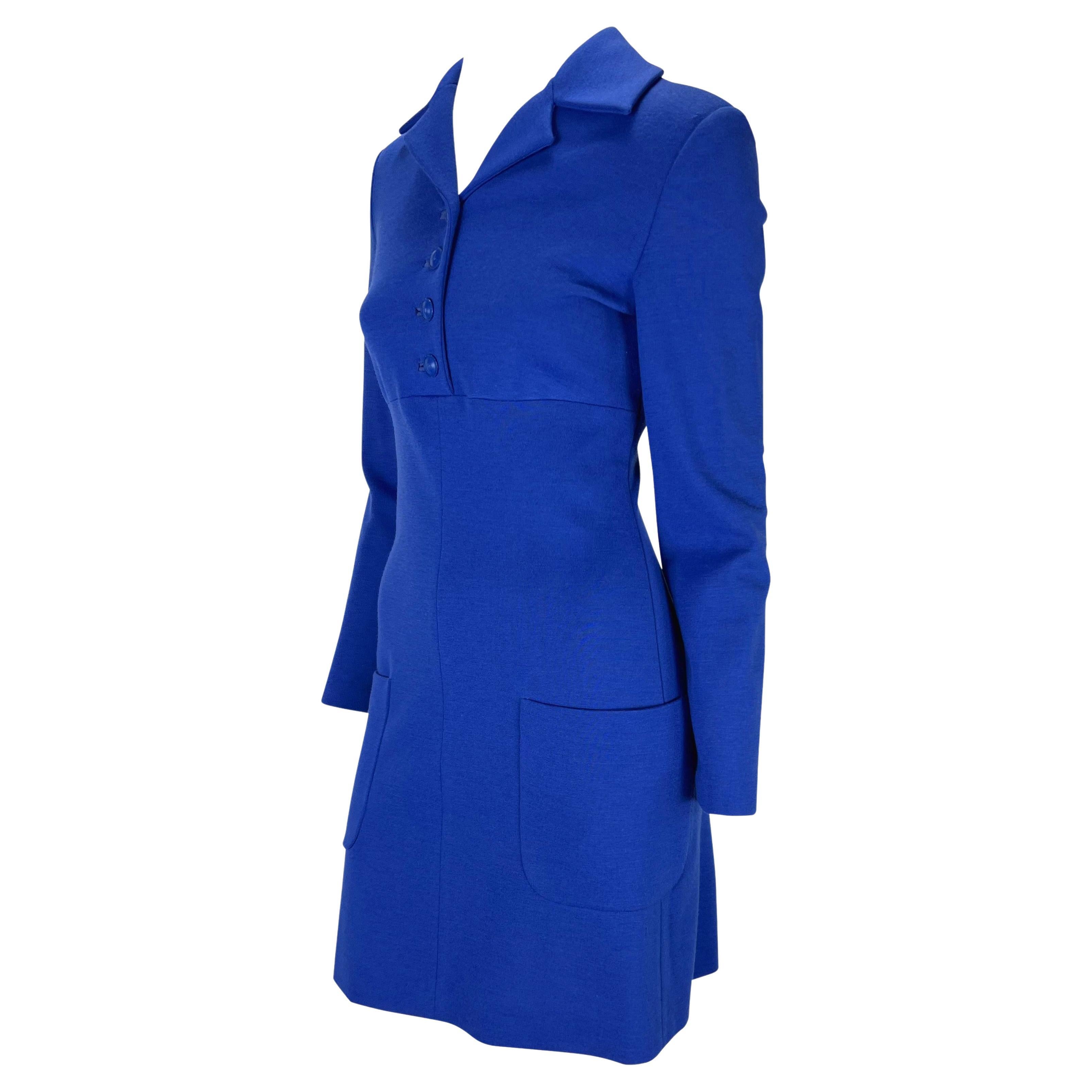 Voici une magnifique robe à col bleu conçue par Gianni Versace. Issue de la collection automne/hiver 1996, cette robe bleu roi présente des manches longues, des fermetures à boutons au niveau du buste, un col et des poches sur les hanches. Une