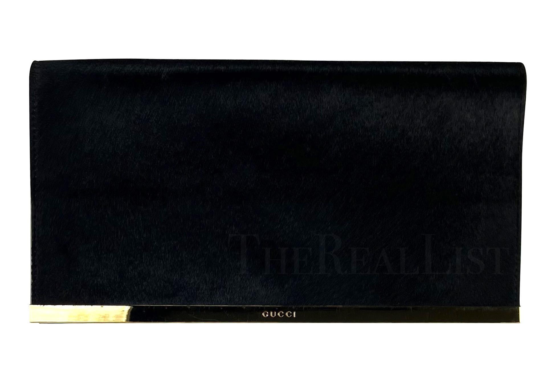 Presenting a chic black Gucci pony hair clutch, designed by Tom Ford. From the Fall/Winter 1996 collection, this clutch is constructed entirely from black pony hair and punctuated with a delicate gold-tone metal accent. This piece of quiet luxury