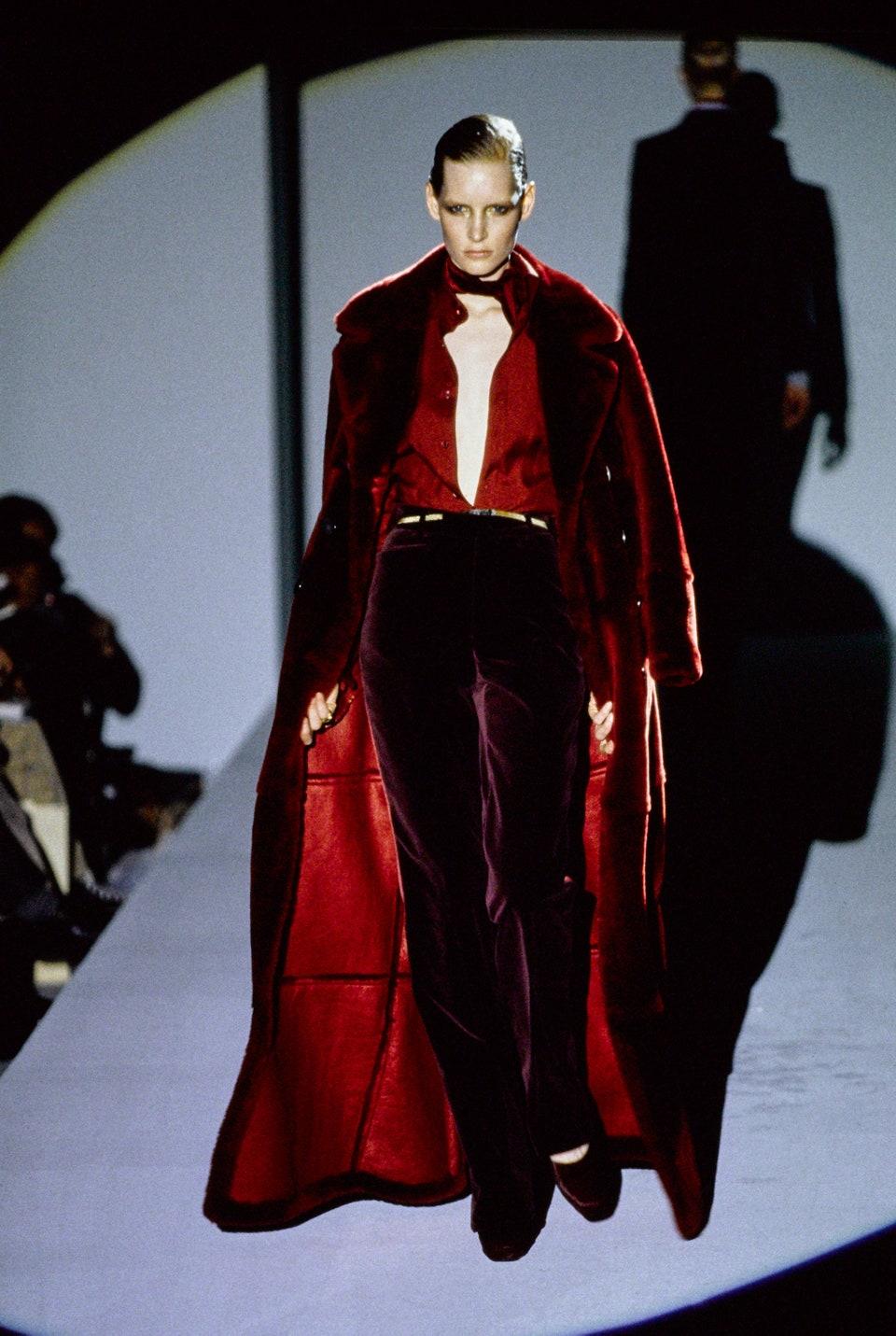 Présentation d'un incroyable manteau en shearling rouge Gucci à double boutonnage, dessiné par Tom Ford. Dans la collection Automne/Hiver 1996, un manteau long similaire a fait ses débuts sur le podium de la saison dans le look 42, porté par Kirsten