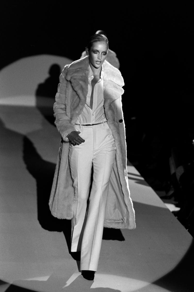 Presenting a brown faux fur double-breasted Gucci full-length coat with a large peak lapel and collar, designed by Tom Ford. The creme version of this coat was debuted on the F/W 1996 runway on look 29 and was modeled by Georgina Grenville. This
