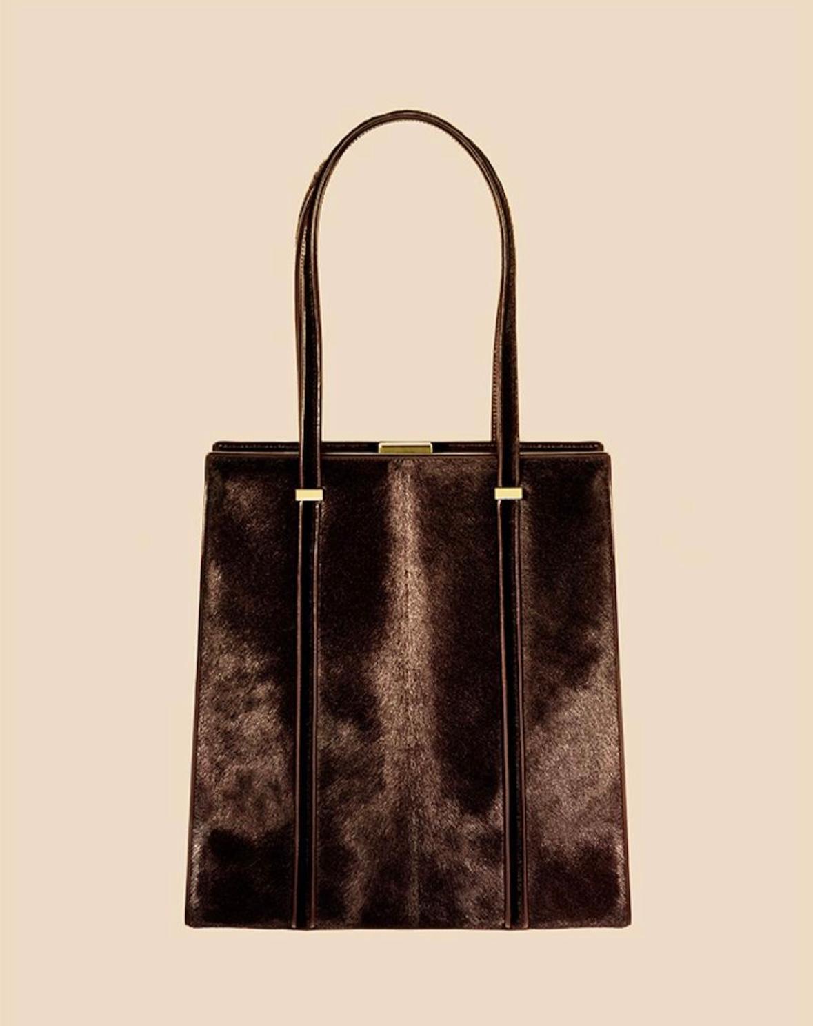 This truly incredible black crocodile Gucci top handle bag was designed by Tom Ford for the Fall/Winter 1996 collection with the pony hair version highlighted in the season's ad campaign. Constructed entirely of black crocodile, this bag features a