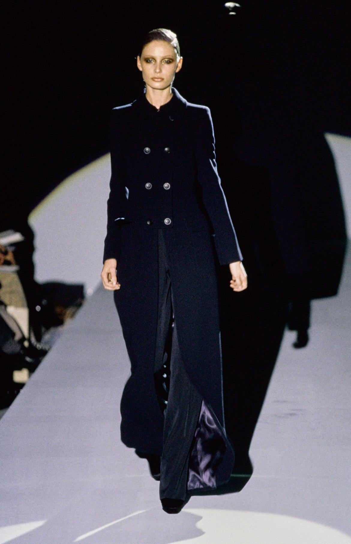 Presenting a fabulous navy wool oversized Gucci trench coat, designed by Tom Ford. From the Fall/Winter 1996 collection, this coat debuted on the season's runway and features a large abstract Gucci 'G' at the back that was heavily used in this