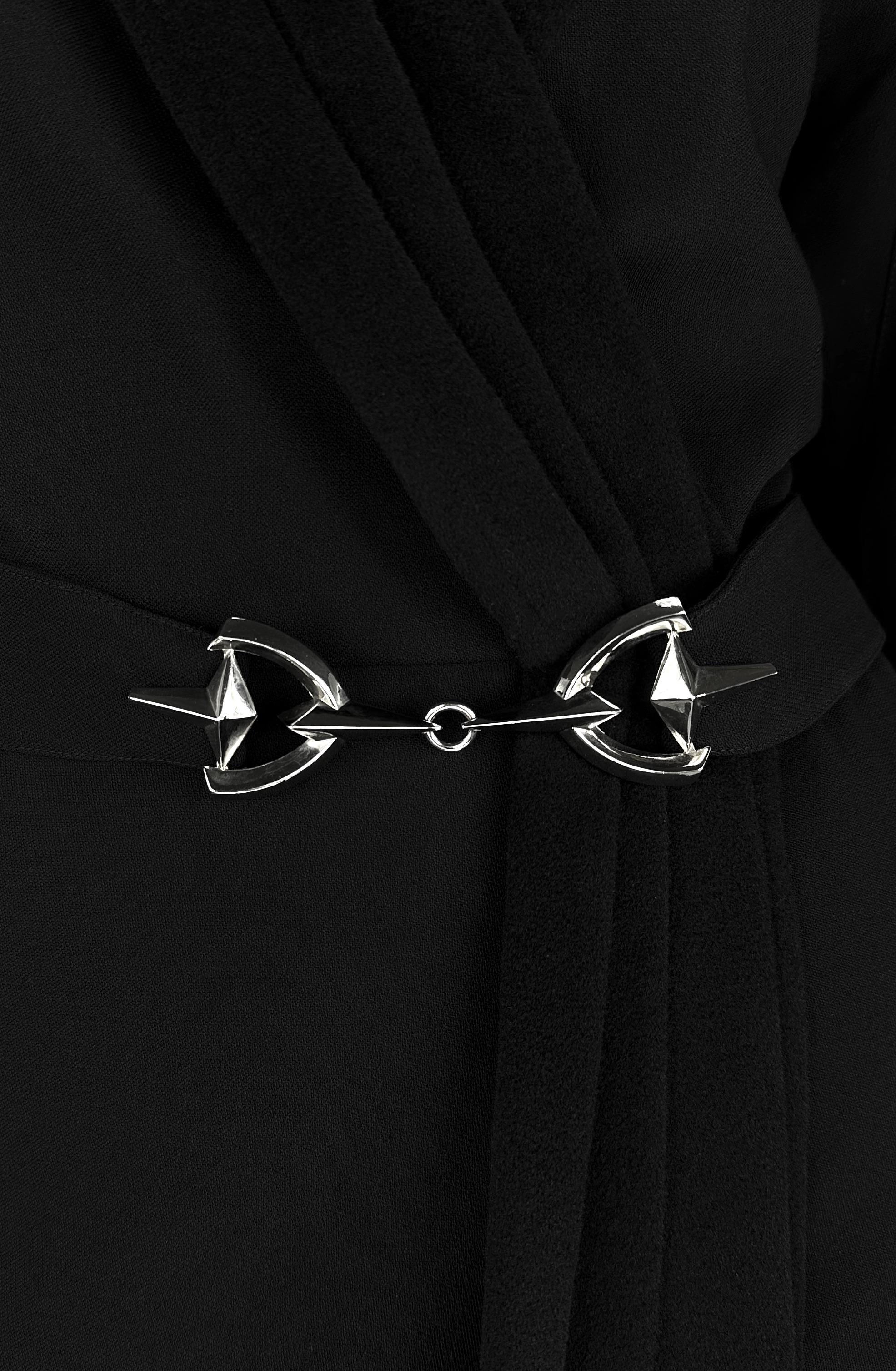 Questo abito cappotto di Thierry Mugler della collezione Autunno/Inverno 1996 presenta un elegante collo a scialle e una caratteristica fibbia a forma di cavallo in vita. Il design fonde l'iconica sartoria strutturata di Mugler con un drappeggio