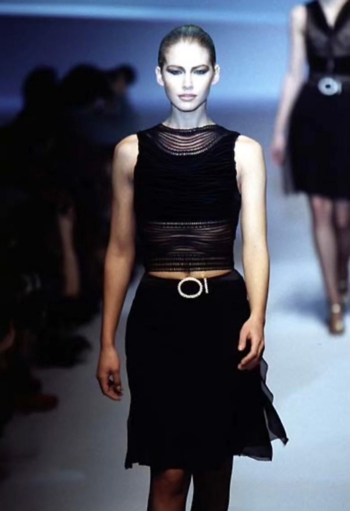 Valentino Garavani designed this chic sheer black skirt for the Fall/Winter 1996 collection. This skirt debuted on the season's runway and is constructed of a light silk chiffon that is slightly sheer. This skirt is elevated with a gold-tone faux
