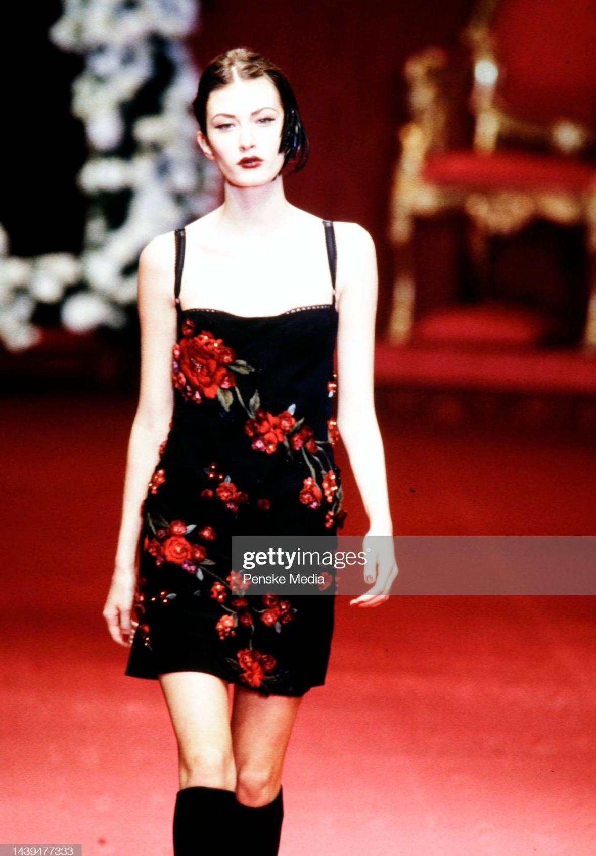 Presenting a beautiful black and red floral dress designed by Dolce and Gabbana for their Fall/Winter 1997 collection. This gorgeous square-neckline dress debuted on the season's runway covered in vibrant red flower appliqués. The dress has an