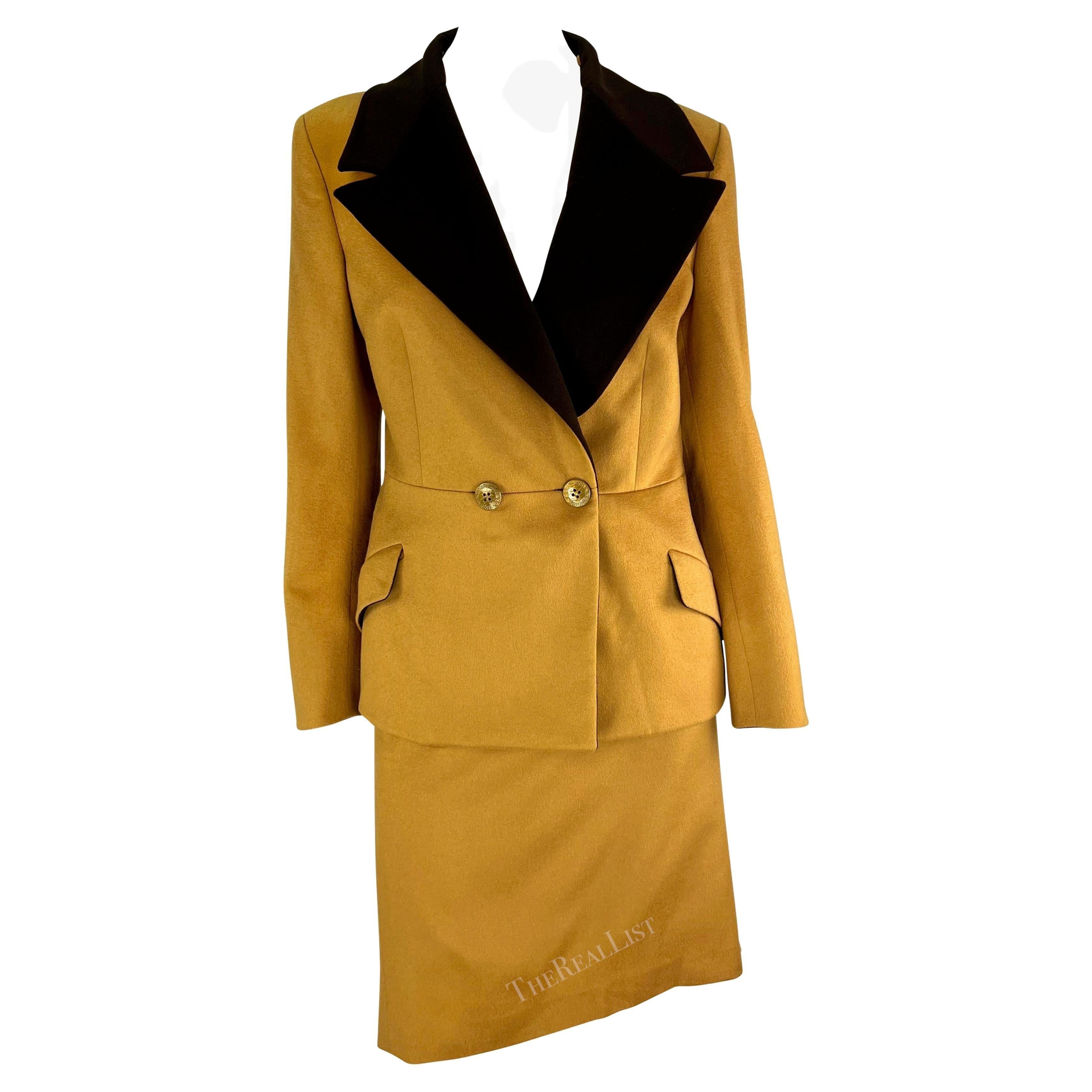 Nous vous présentons un fabuleux tailleur jupe de couleur fauve, dessiné par Gianni Versace pour la collection automne/hiver 1997. Cet ensemble chic comprend un blazer à double boutonnage associé à une jupe assortie. La veste comporte des poches