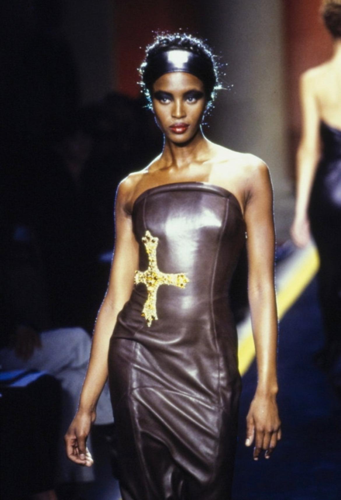 Nous vous présentons une magnifique robe tube Versace en cuir noir, sans bretelles, dessinée par Gianni Versace. Dans la collection Automne/Hiver 1997, des robes tubes similaires, entièrement en cuir noir, ont fait leur apparition sur les podiums de