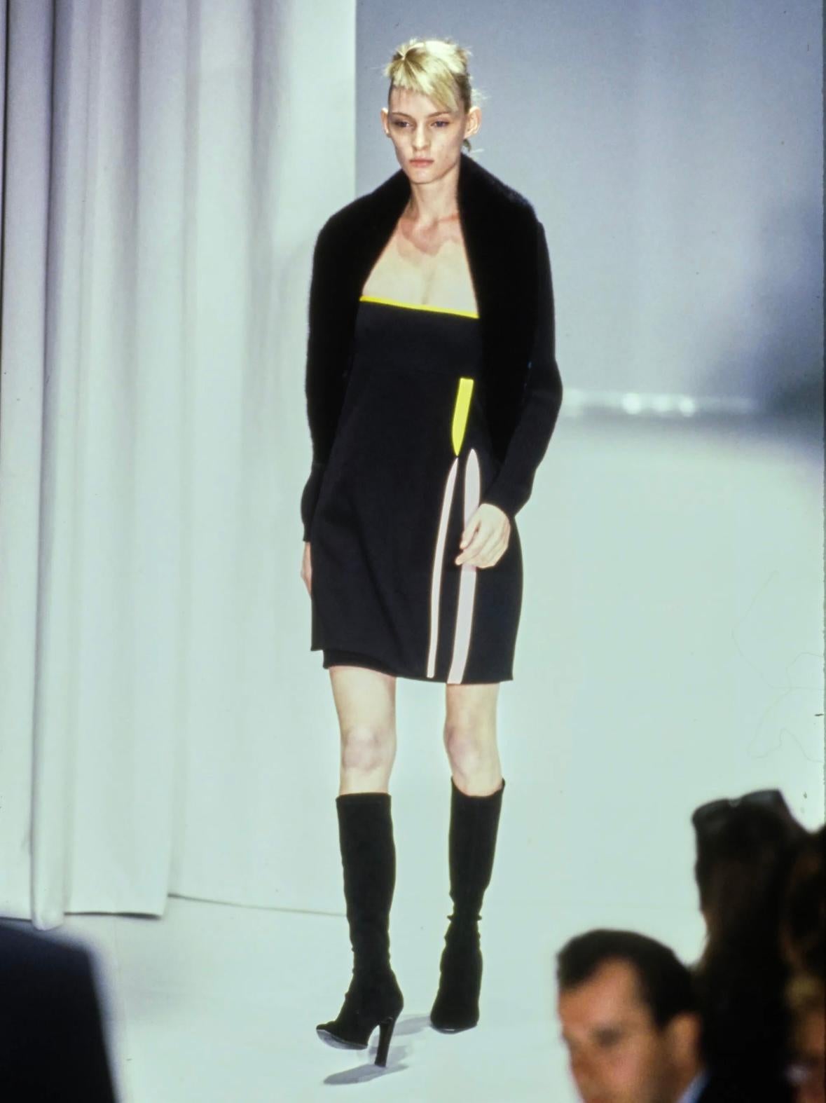 Dieses Minikleid von Gianni Versace, das aus der letzten Kollektion des gleichnamigen Modehauses stammt, wurde auf dem Laufsteg der Saison als Teil des Looks 40 präsentiert, der von  Amy Wesson. Dieses schicke schwarze Minikleid hat eine Wickeloptik