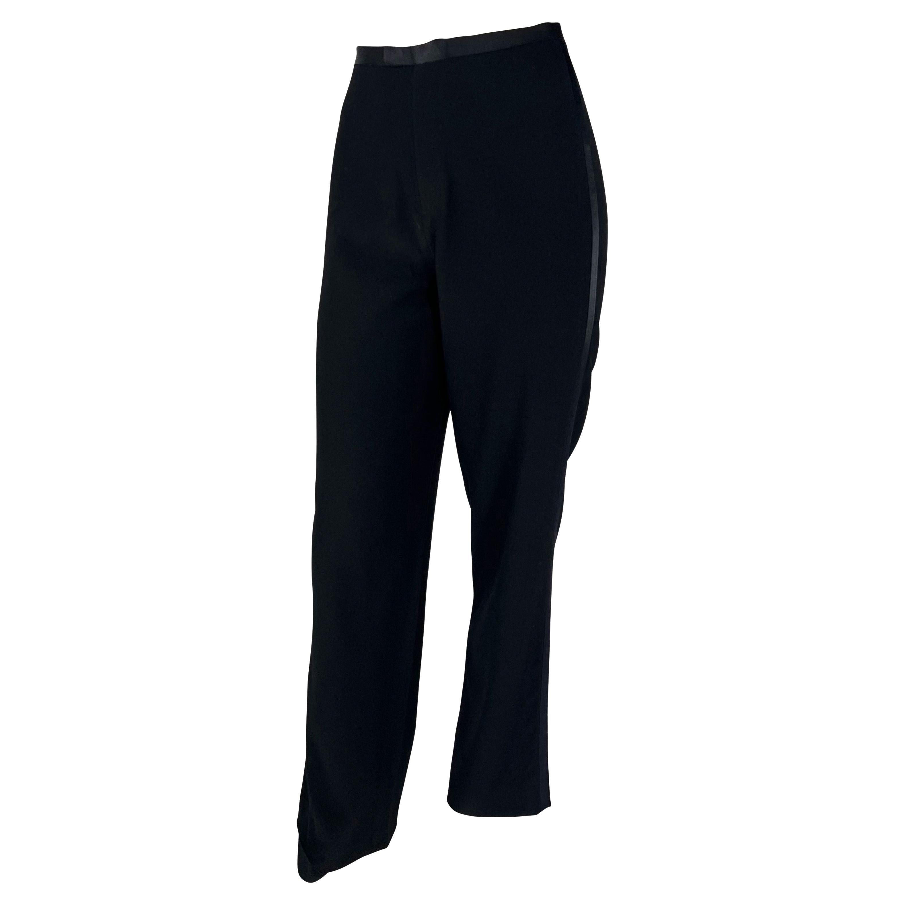 TheRealList presents: a pair of black wool Gucci tuxedo pants, designed by Tom Ford. From the Fall/Winter 1997 collection, these tuxedo-style pants feature a flare cut and are made complete with black satin accents at the waist and down each leg.