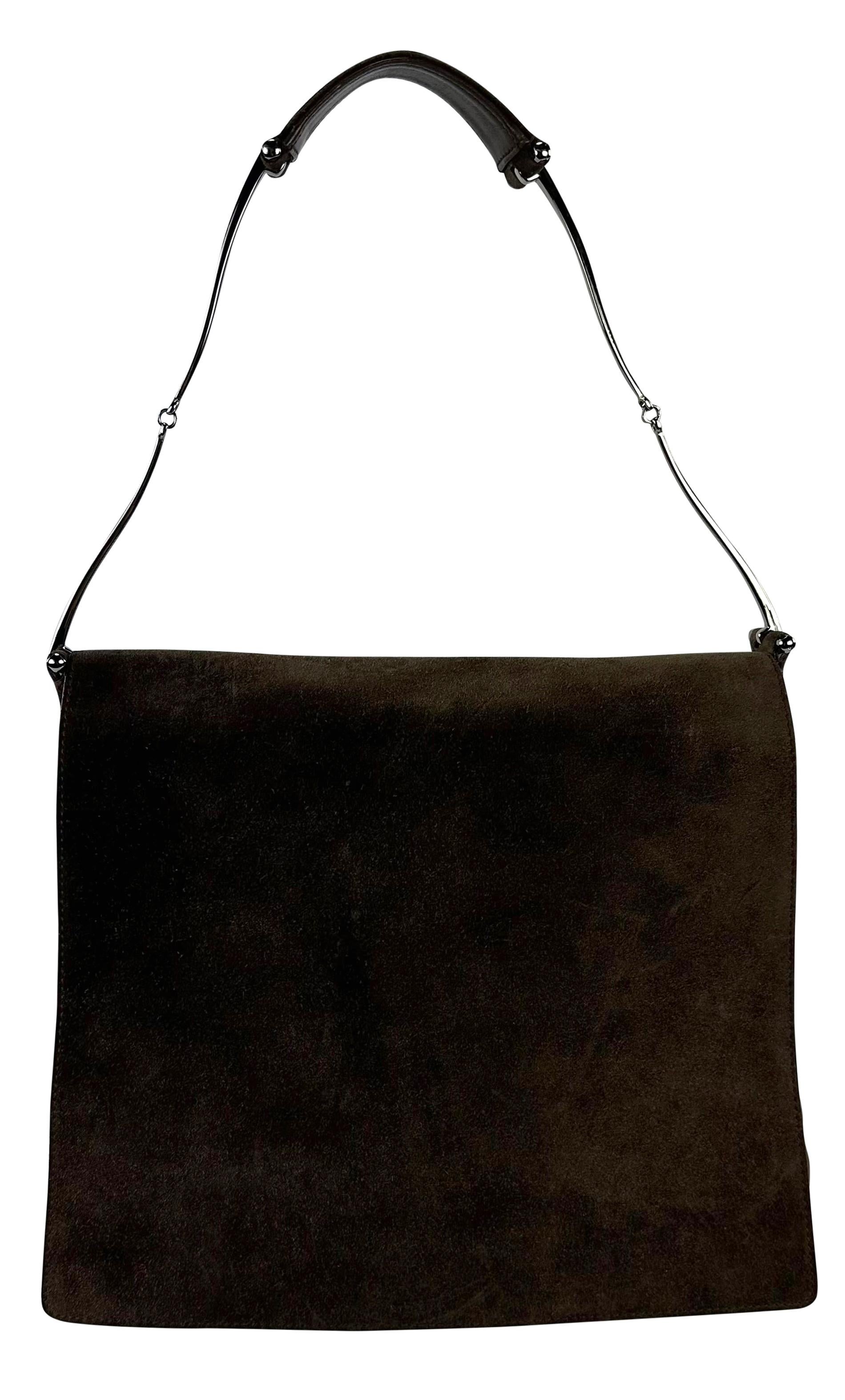 Tom Ford designed this brown suede flap bag for his Fall/Winter 1997 collection at Gucci. This chic bag is crafted from rich brown suede, it features subtle thin metal horsebit details, a flap closure, and a shoulder strap for easy wear. This bag