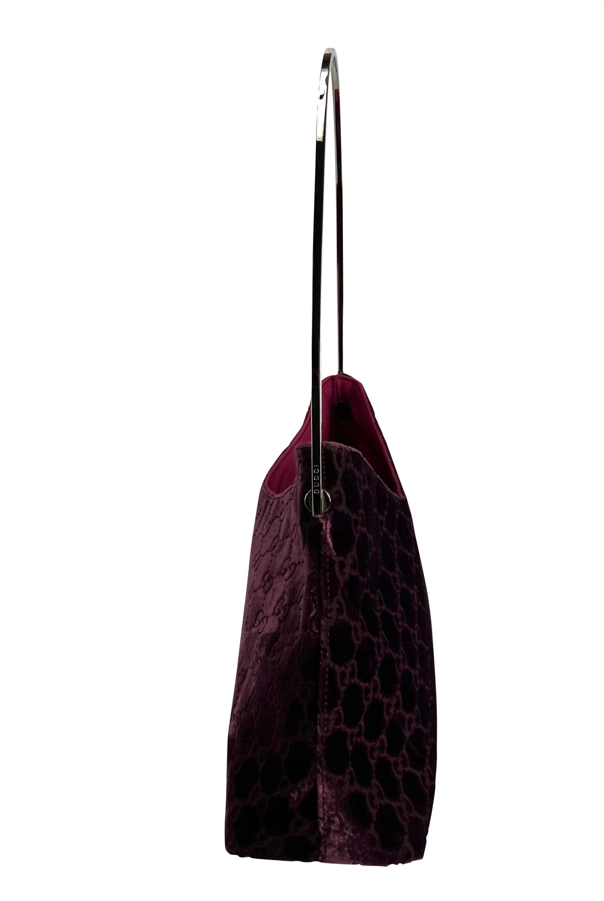 Ce sac seau à monogramme Gucci 'GG' bordeaux, conçu par Tom Ford, est un modèle emblématique. Issu de la collection automne/hiver 1997, ce fabuleux sac est constitué d'un corps en velours de soie violet foncé/bordeaux et d'une poignée argentée. Le