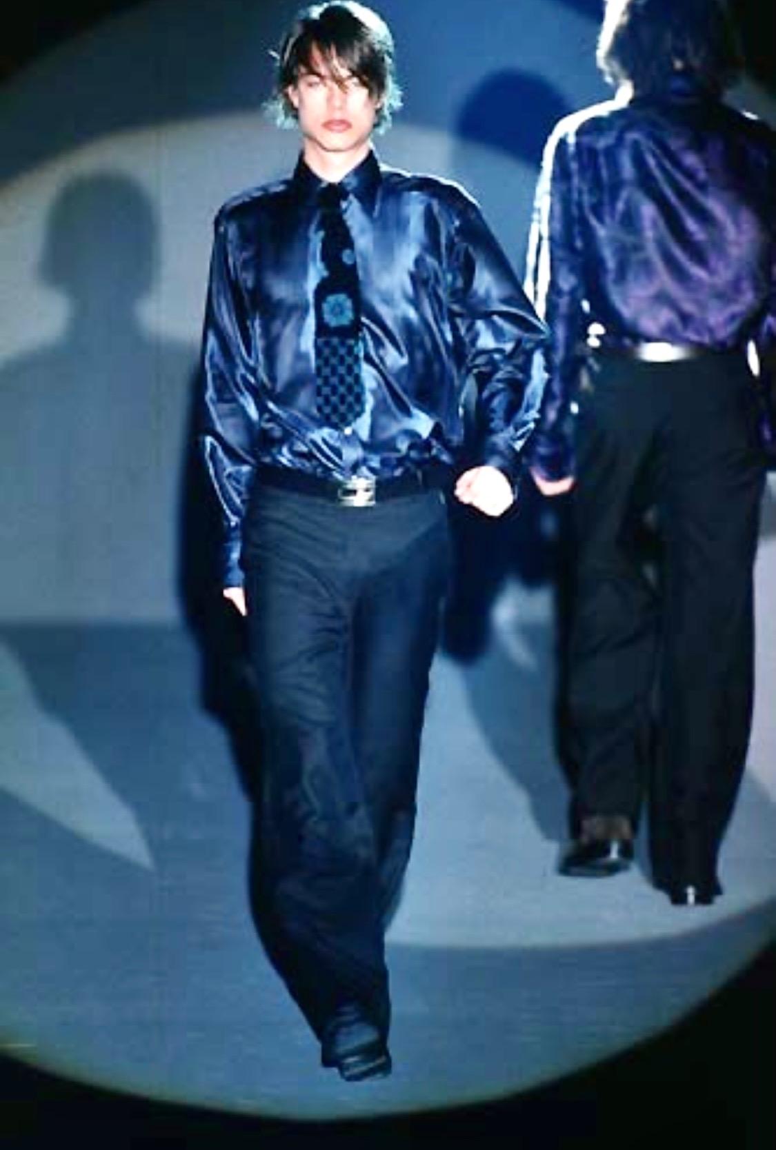 Te presentamos una camisa abotonada de seda azul iridiscente diseñada por Tom Ford. De la colección Otoño/Invierno 1997, este top apareció en la pasarela de la temporada en múltiples variaciones de color y es una de las piezas más notables de Ford