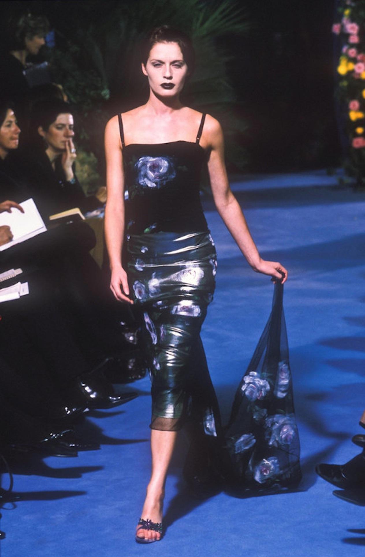 Elle présente une superbe robe Dolce & Gabbana en maille noire. Issue de la collection automne-hiver 1998, cette robe deux pièces se compose d'une jupe intérieure et d'une robe extérieure en maille. Entièrement réalisée en maille noire, cette robe