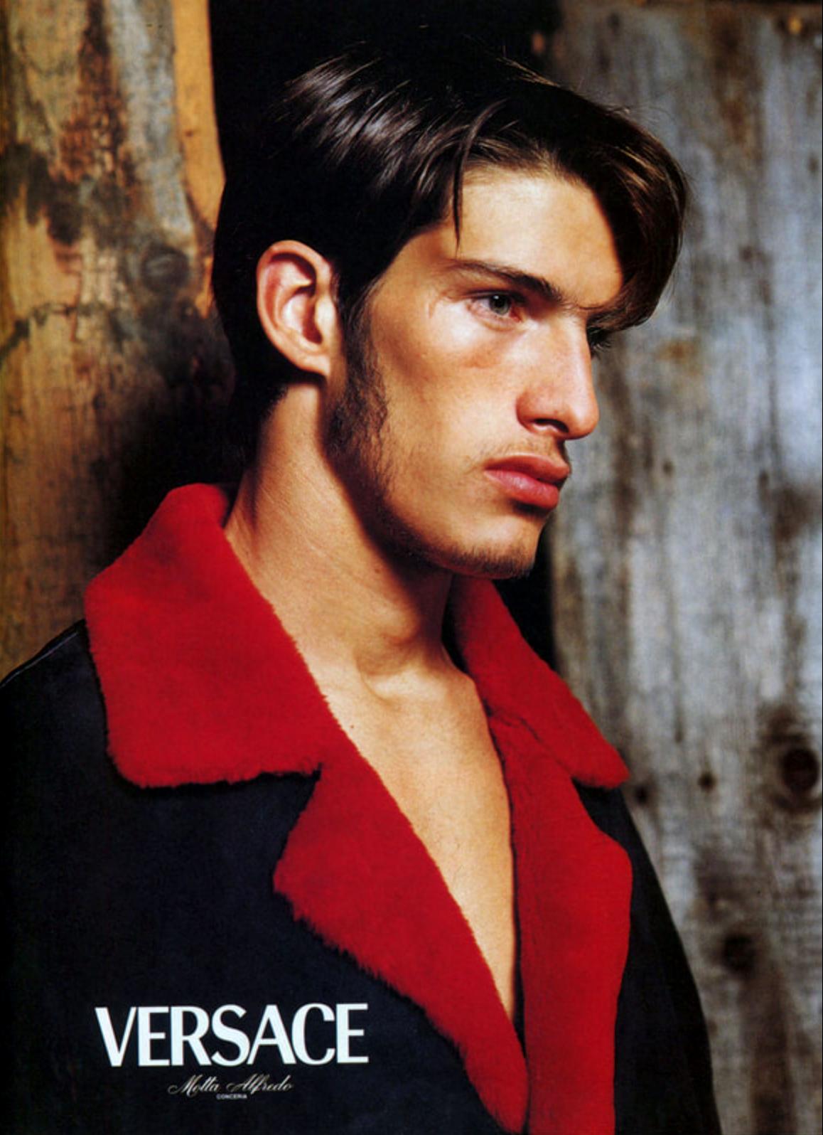 Conçu par Donatella pour la collection automne/hiver 1998 de Gianni Versace, ce manteau en daim noir présente un intérieur en fourrure de shearling rouge. Le col surdimensionné et les poignets et le col contrastés créent un visuel saisissant,