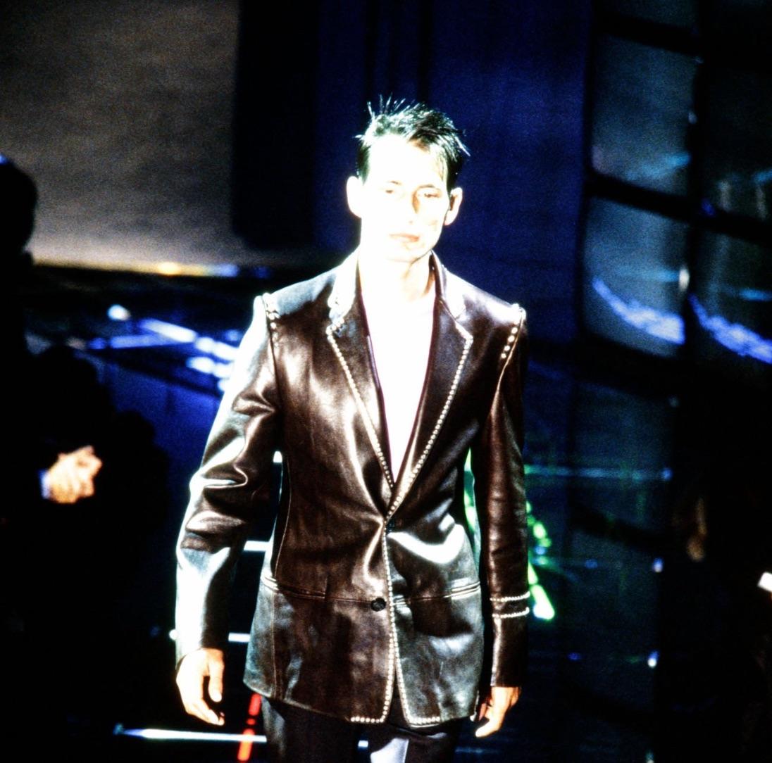 This Fall/Winter 1998 Gianni Versace was designed Donatella and debuted on the season's men's runway. This chic leather blazer jacket is crafted from supple black leather with studded detailing along the lapel, shoulders, and sleeves. 

Approximate