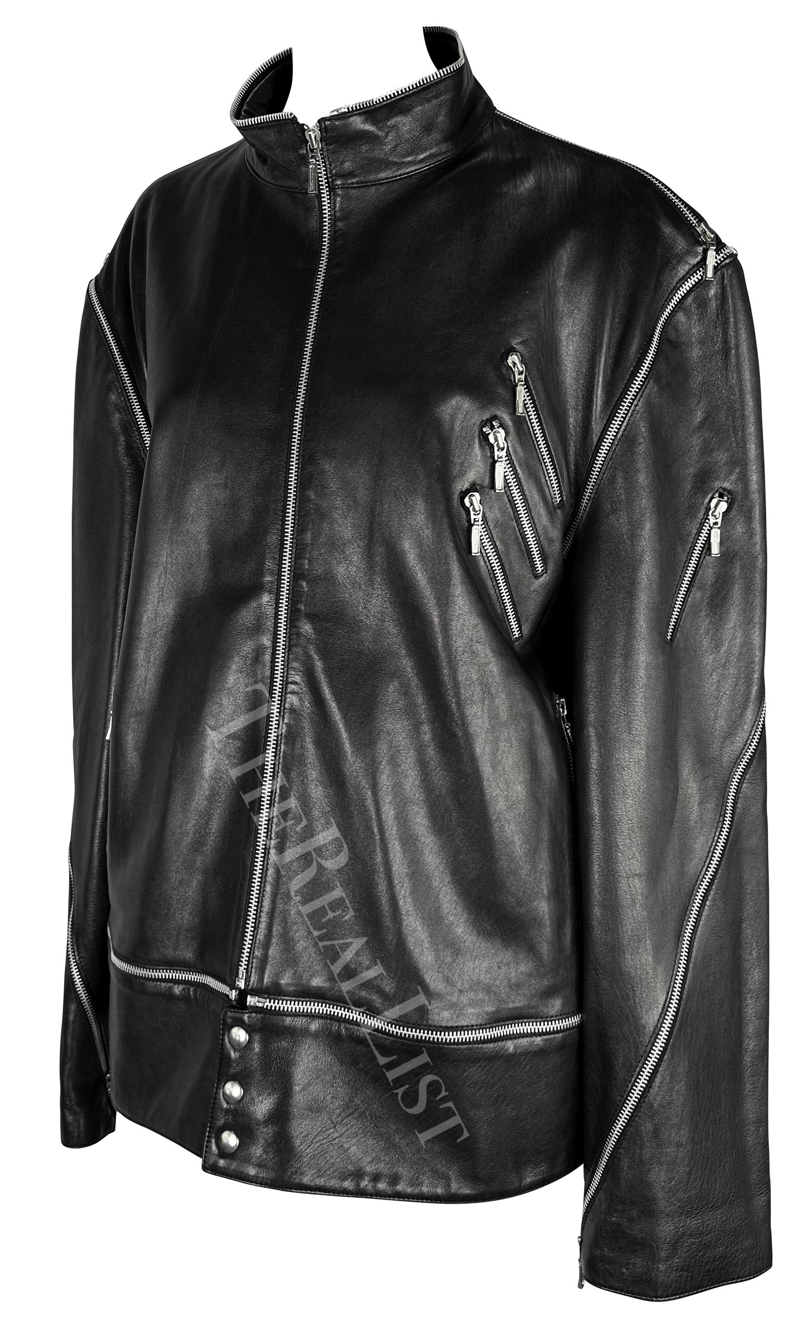 This chic, oversized black leather moto jacket by Gianni Versace, designed by Donatella Versace, debuted in light tan on the Fall/Winter 1998 men's runway. This stunning jacket features a standing collar and is crafted entirely from leather, adorned