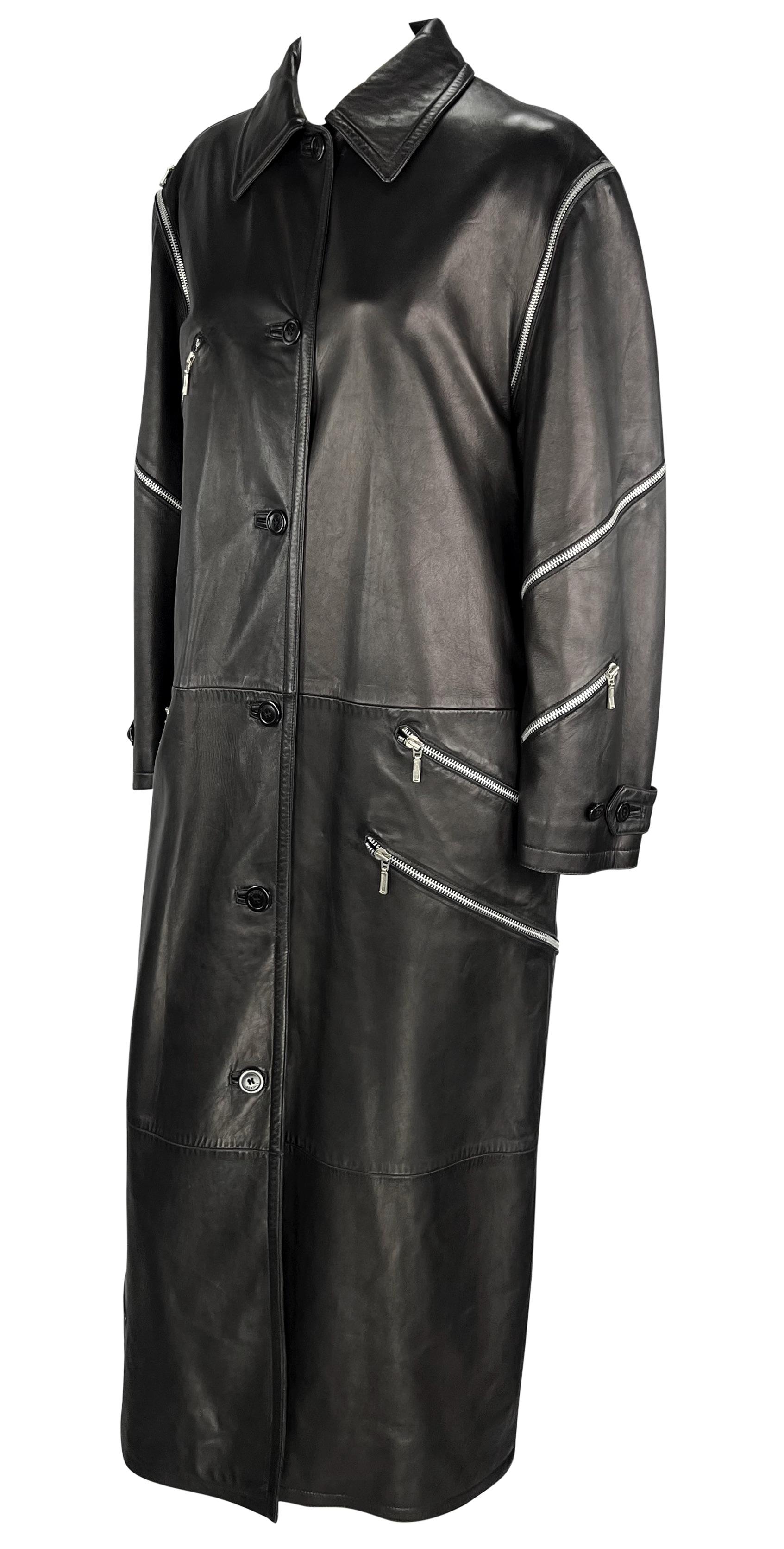 Dalla collezione Autunno/Inverno 1998, una variante di questo cappotto a tutta lunghezza ha debuttato sulla passerella maschile della stagione in tinta chiara. Disegnato da Donatella Versace, questo cappotto interamente in pelle nera presenta un