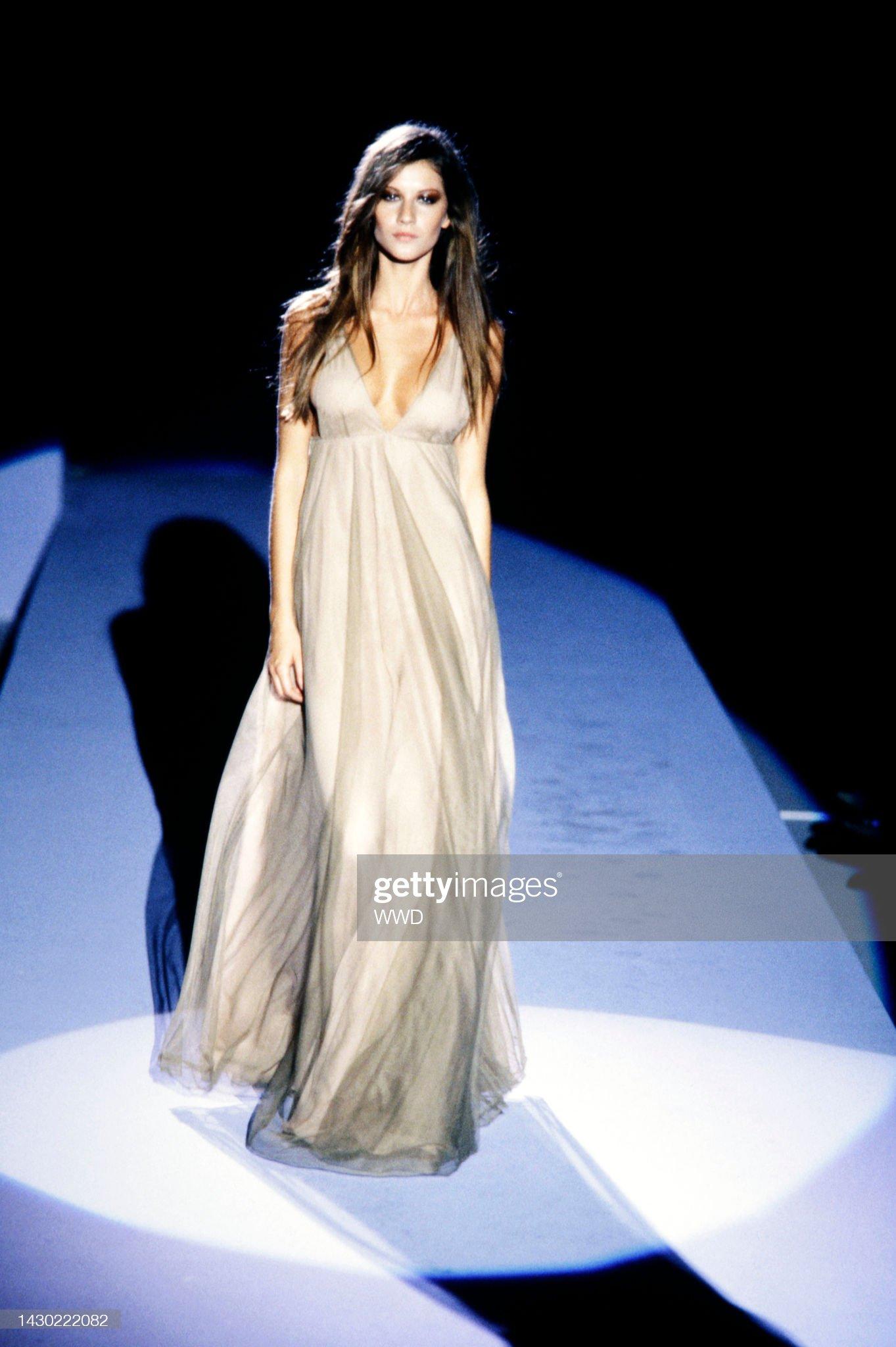 Présentation d'une fabuleuse robe Gucci en tulle fauve, conçue par Tom Ford. Issue de la collection automne-hiver 1998, cette robe fantaisiste a clôturé le défilé de la saison, portée par Gisele Bündchen, et a également été mise en valeur dans la