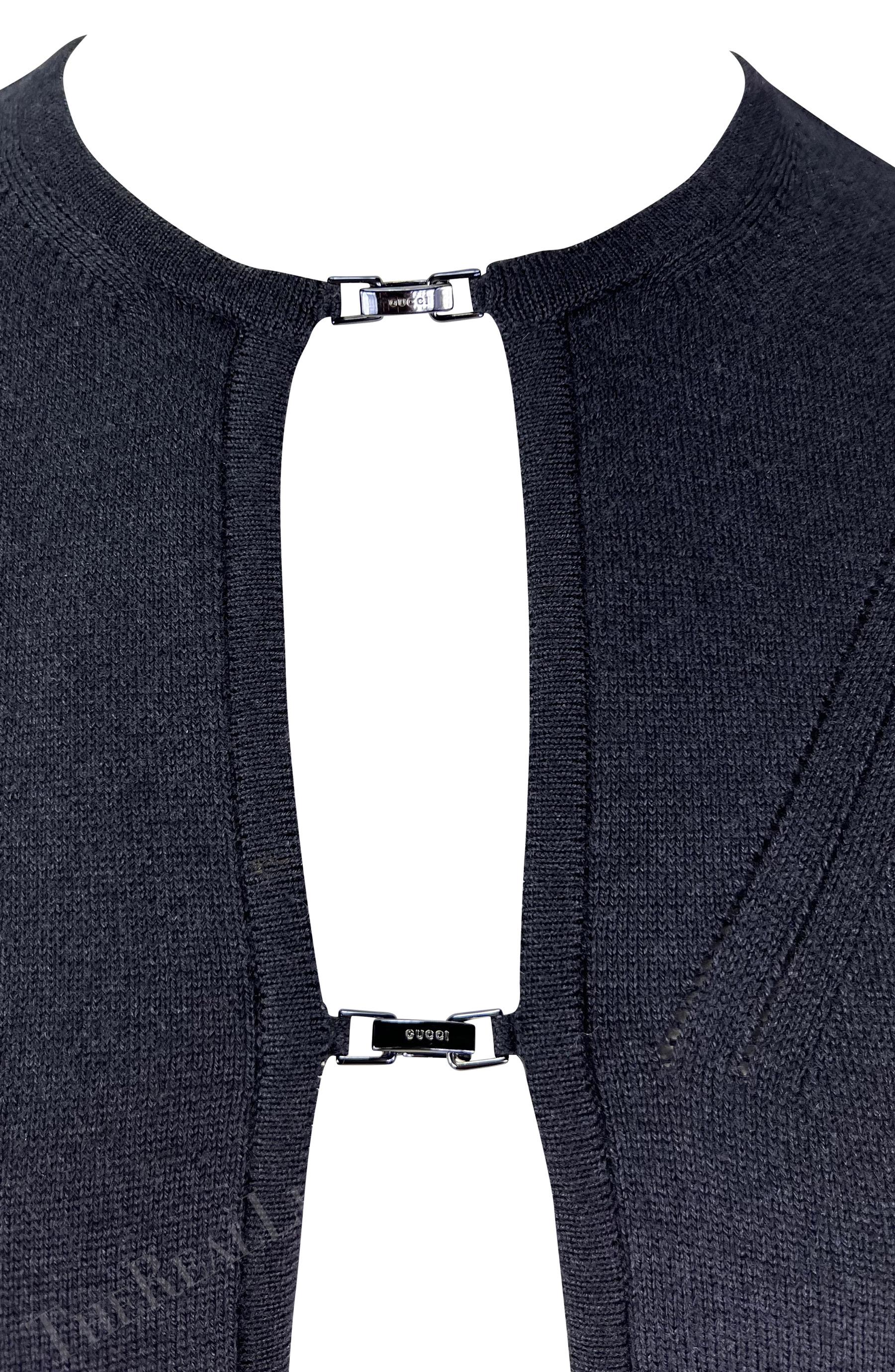Ich präsentiere eine schwarze, offene Strickjacke von Gucci, entworfen von Tom Ford. Diese unglaubliche Strickjacke aus der Herbst/Winter-Kollektion 1998 verfügt über zwei Verschlüsse auf der Vorderseite, die jeweils mit dem Schriftzug 