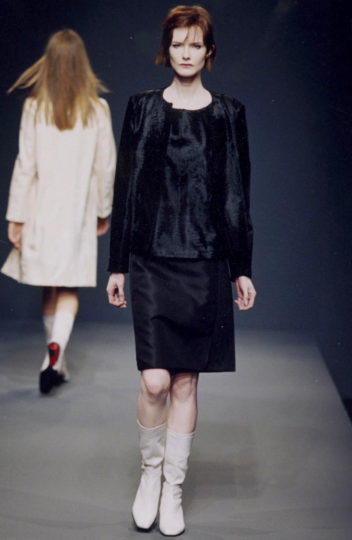 From the late Fall/Winter 1998 collection, this black Prada sleeveless top debuted on the season's runway as part of look look 8 on Marcelle Bittar with a similar top also appearing on Erin O'Connor. This chic runway top is constructed of genuine
