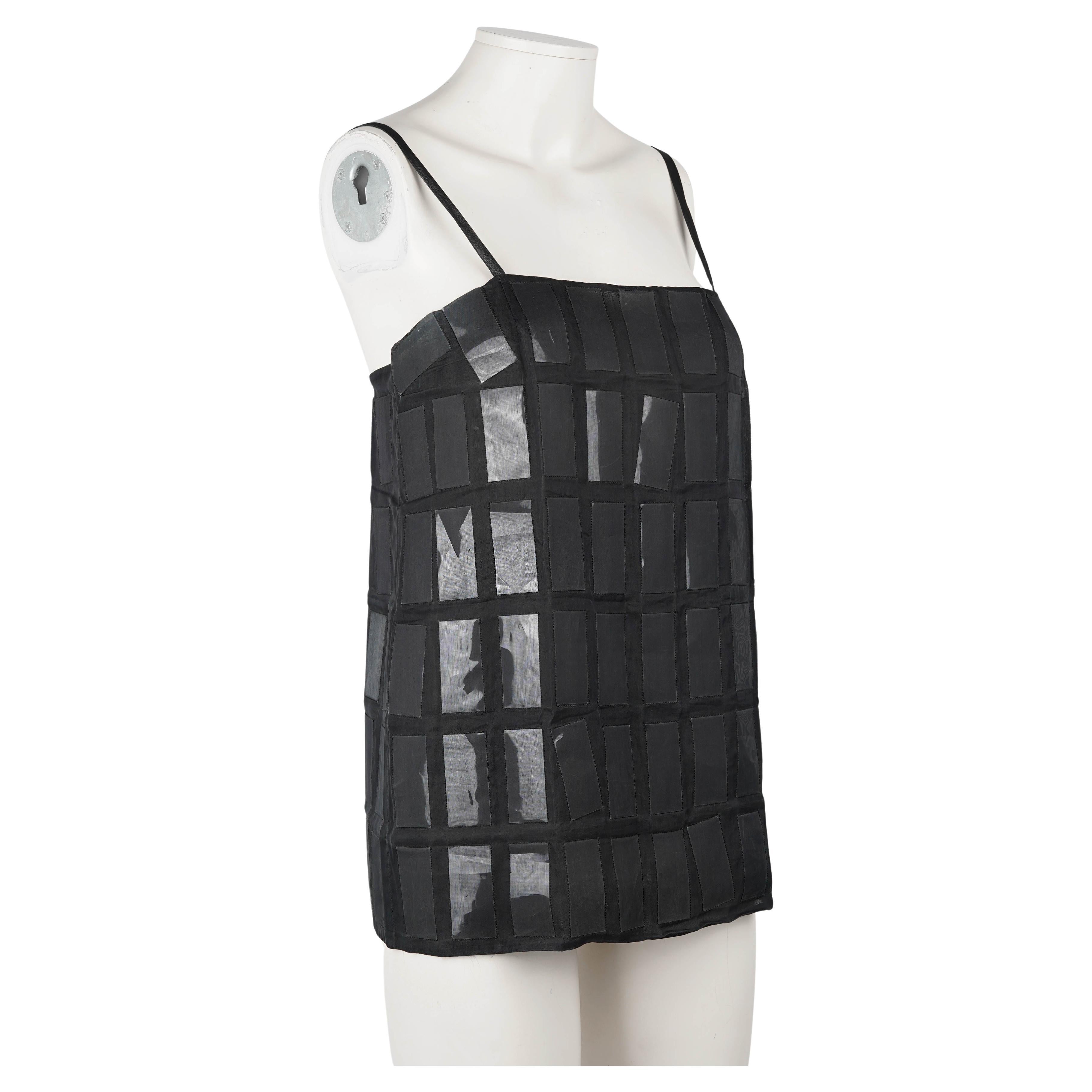 A striking embodiment of Miuccia Prada's continuous risk taking, this F/W 1998 runway camisole captures the essence of the heavily French futurist indebted collection. Crafted from sheer black silk organza, the camisole is layered with gleaming,