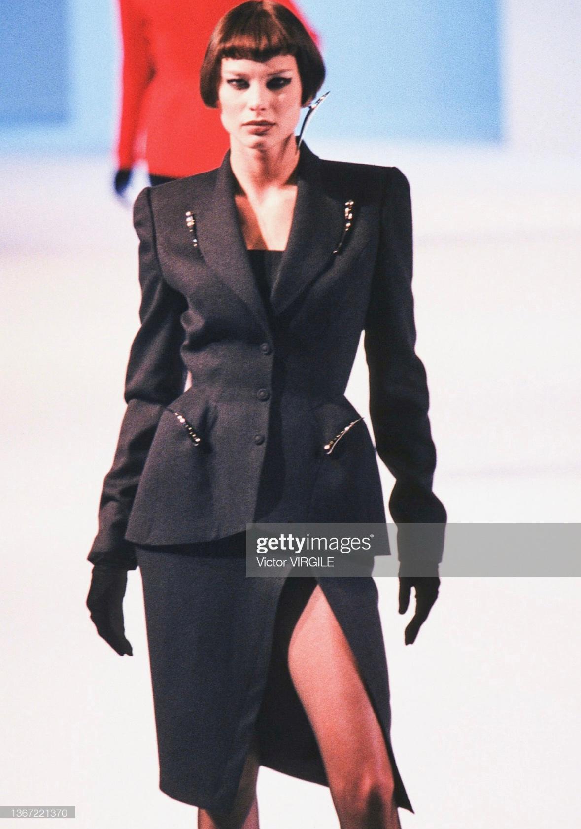 Presenting a sculptural purple Thierry Mugler skirt suit, designed by Manfred Mugler. From the Fall/Winter 1998 collection, this incredible suit debuted in the season's runway presentation. The blazer features large sculptural silver-tone elements