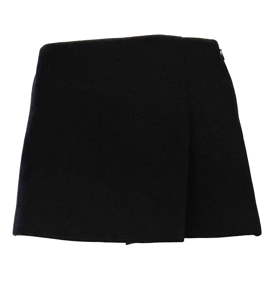 This Dolce & Gabbana super mini skirt suit from the Fall/Winter 1999 collection features a cropped-sleeve jacket with a sharp collar and minimalist detailing. It is paired with a low-waisted super mini skirt, designed to be worn together or styled