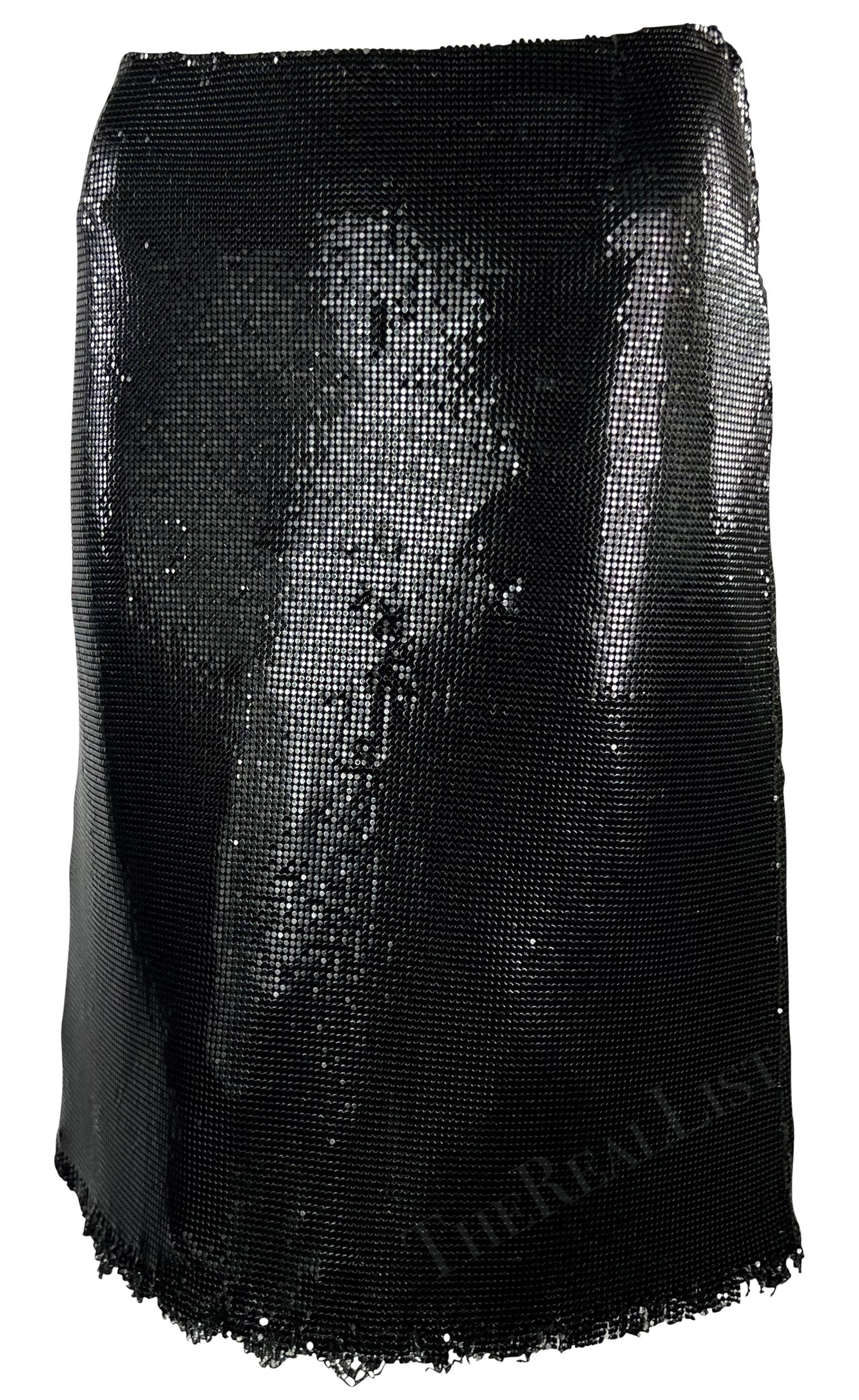 Constructed entirely of shimmery black Oroton chain mail, this Gianni Versace skirt was designed by Donatella Versace for the Fall/Winter 1999 collection. Featuring an a-line silhouette, this fabulous skirt is made complete with a lightly fringed