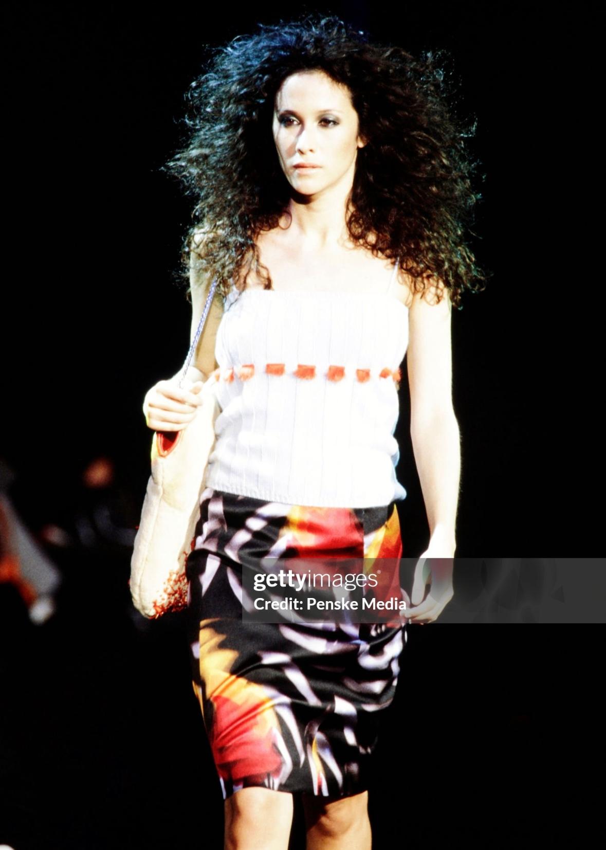 This Gianni Versace by Donatella shoulder bag from Fall/Winter 1999 is crafted in a camel-toned fur adorned with intricate coral embellishments at the base. Featuring a silver-tone chain strap and coral lizard skin accents, a smaller variation of