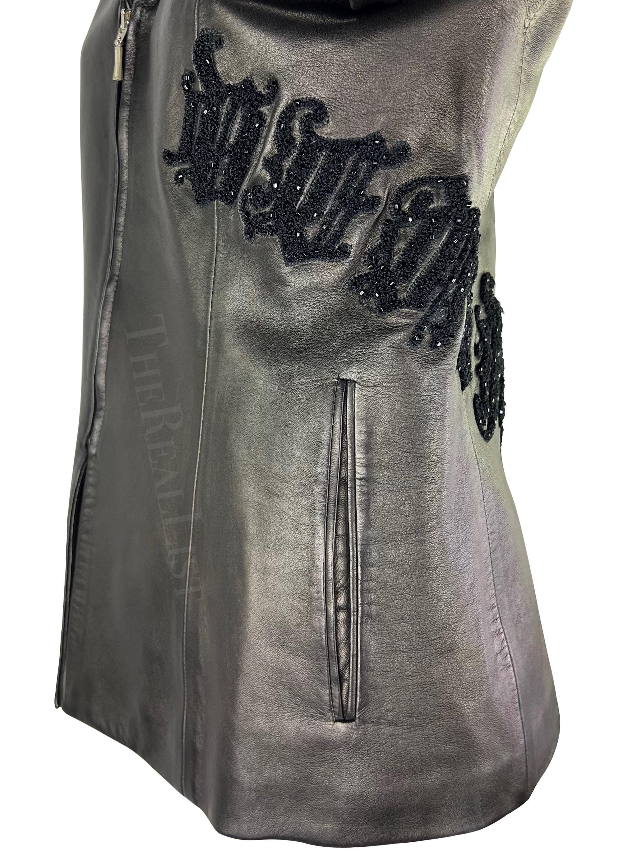 Présentation d'une veste en cuir noire Gianni Versace, dessinée par Donatella Versace. Issue de la collection automne/hiver 1999, cette veste est entièrement en cuir et présente un col rabattu et une fermeture à glissière. La veste est rehaussée