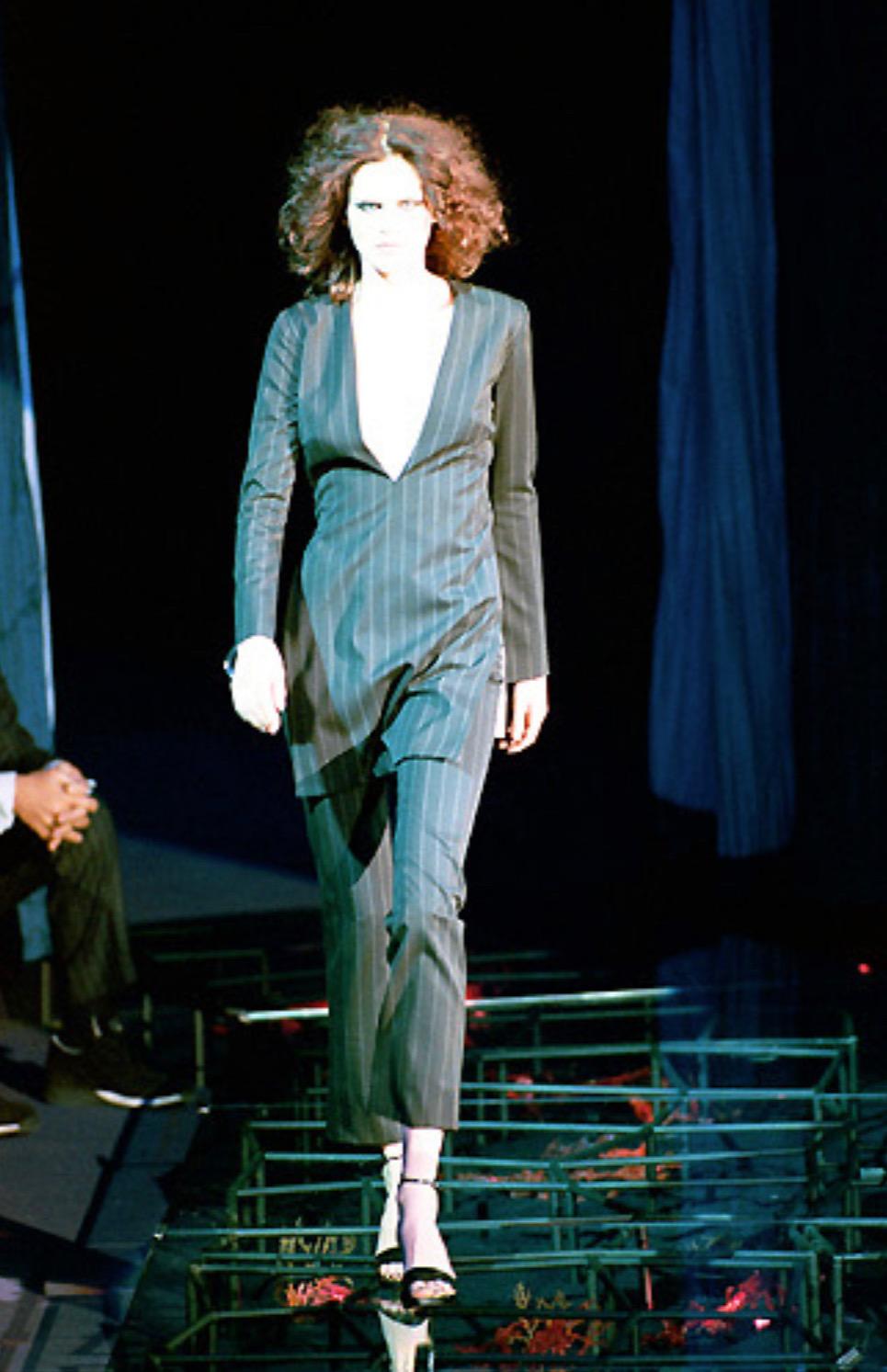 Presenting a gorgeous pinstripe Gianni Versace pantsuit, designed by Donatella Versace. From the Fall/Winter 1999 collection, this fabulous pantsuit debuted on the season's runway. The set consists of an oversized tunic top with a deep v-neckline,