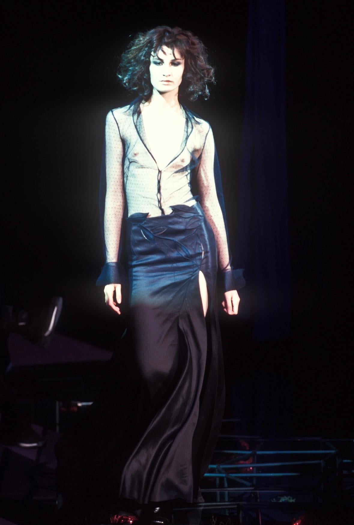 Presenting this incredible black Gianni Versace maxi skirt, designed by Donatella Versace. From the Fall/Winter 1999 collection, this skirt debuted on the season's runway on Erin O'Connor. This dramatic high-slit skirt is adorned with cut-outs and
