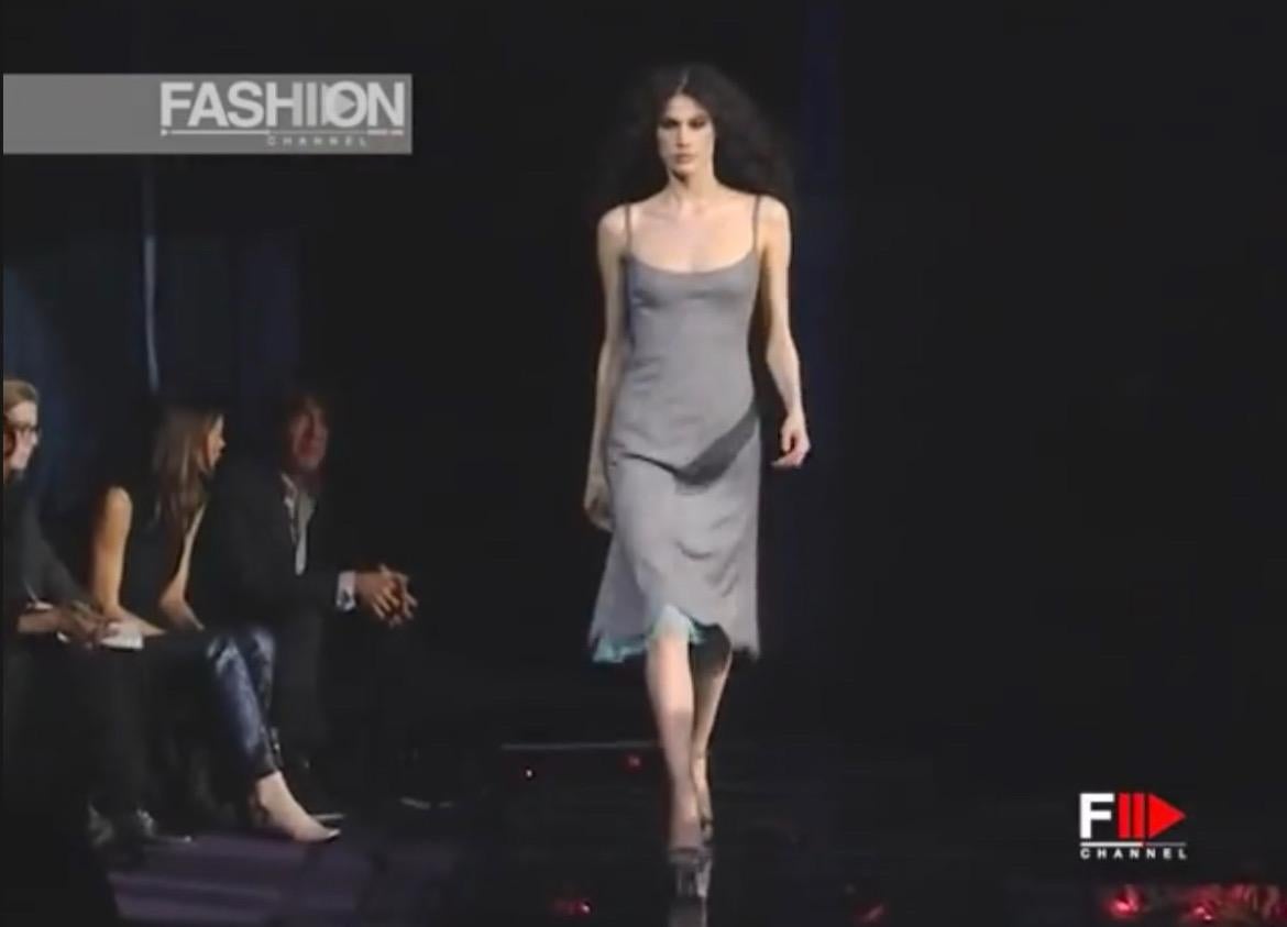 Présentation d'une robe en laine grise Gianni Versace Couture, créée par Donatella Versace. Issue de la collection Automne/Hiver 1999, cette robe a fait ses débuts lors de la présentation du défilé de la saison. Dotée d'une sous-couche de tulle